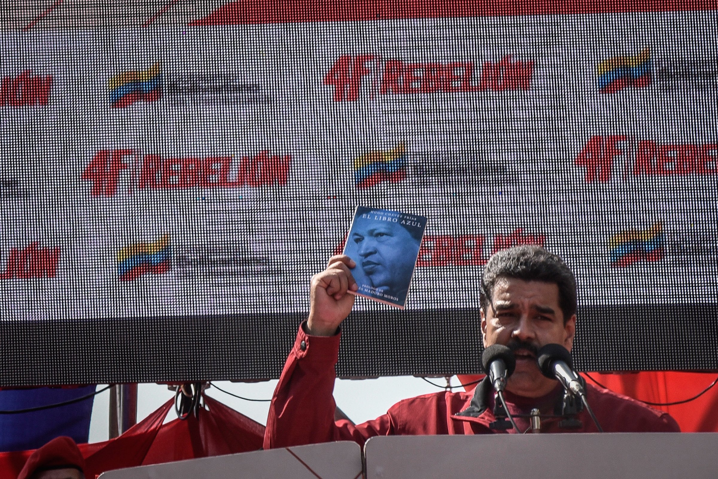 Venezuelan President Nicolás Maduro holds a copy of the El Libro Azul, or The Blue Book, written by his predecessor, Hugo Chávez, while speaking at a rally to commemorate the 24th anniversary of Chávez's failed military coup in Caracas, Venezuela, Feb. 4, 2016.
