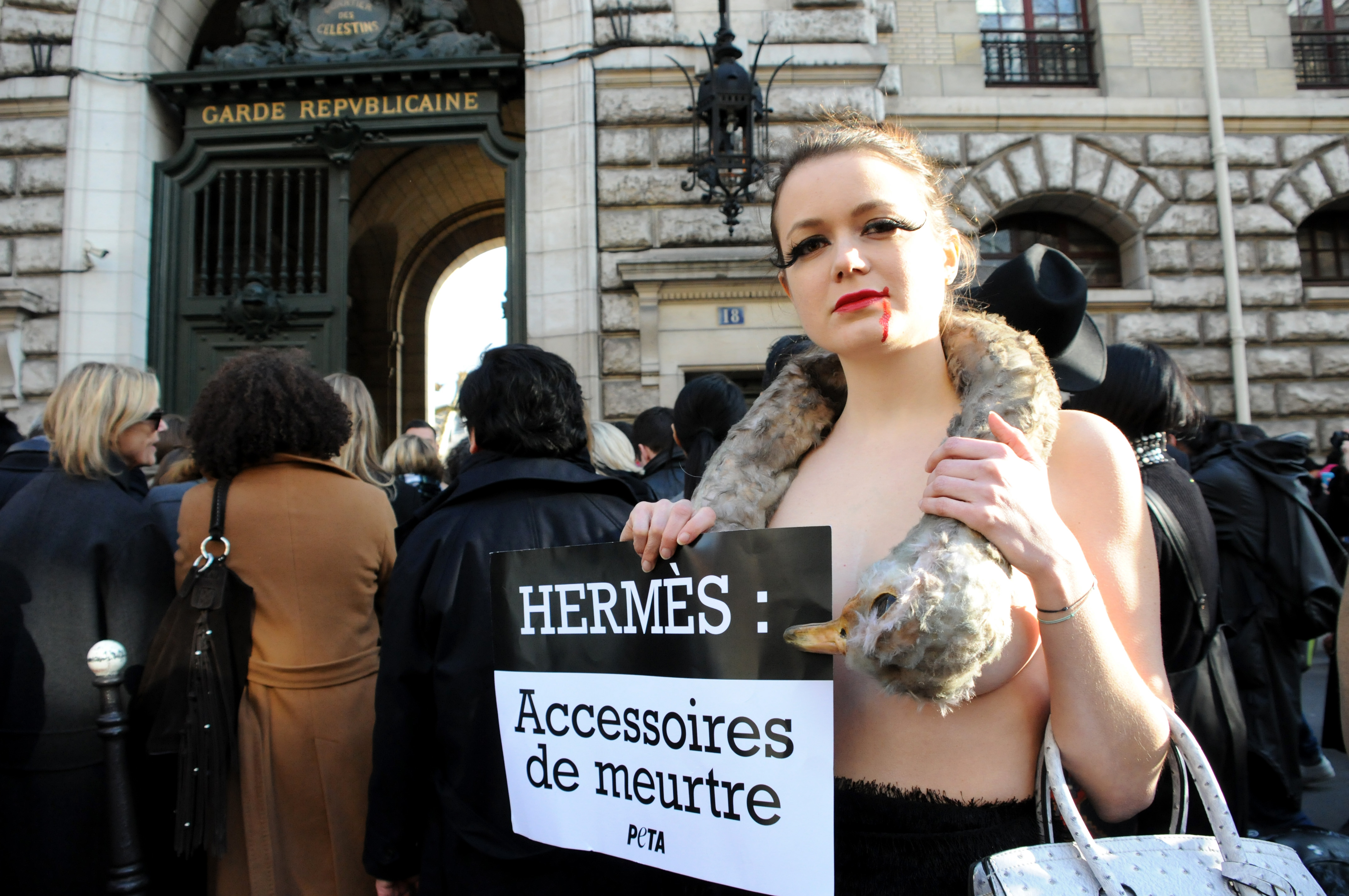 A PETA model wearing a gore-version of Bjork's legendary 'swan-dress', covered with the bloody carcass of an ostrich and carrying a handbag made out of fake ostrich leather, demonstrates outside the Garde Republicaine headquarters during the Hermes fashion show, as part of the Paris Fashion Week, in Paris on March 7, 2016. (Apaydin Alain—Sipa USA)