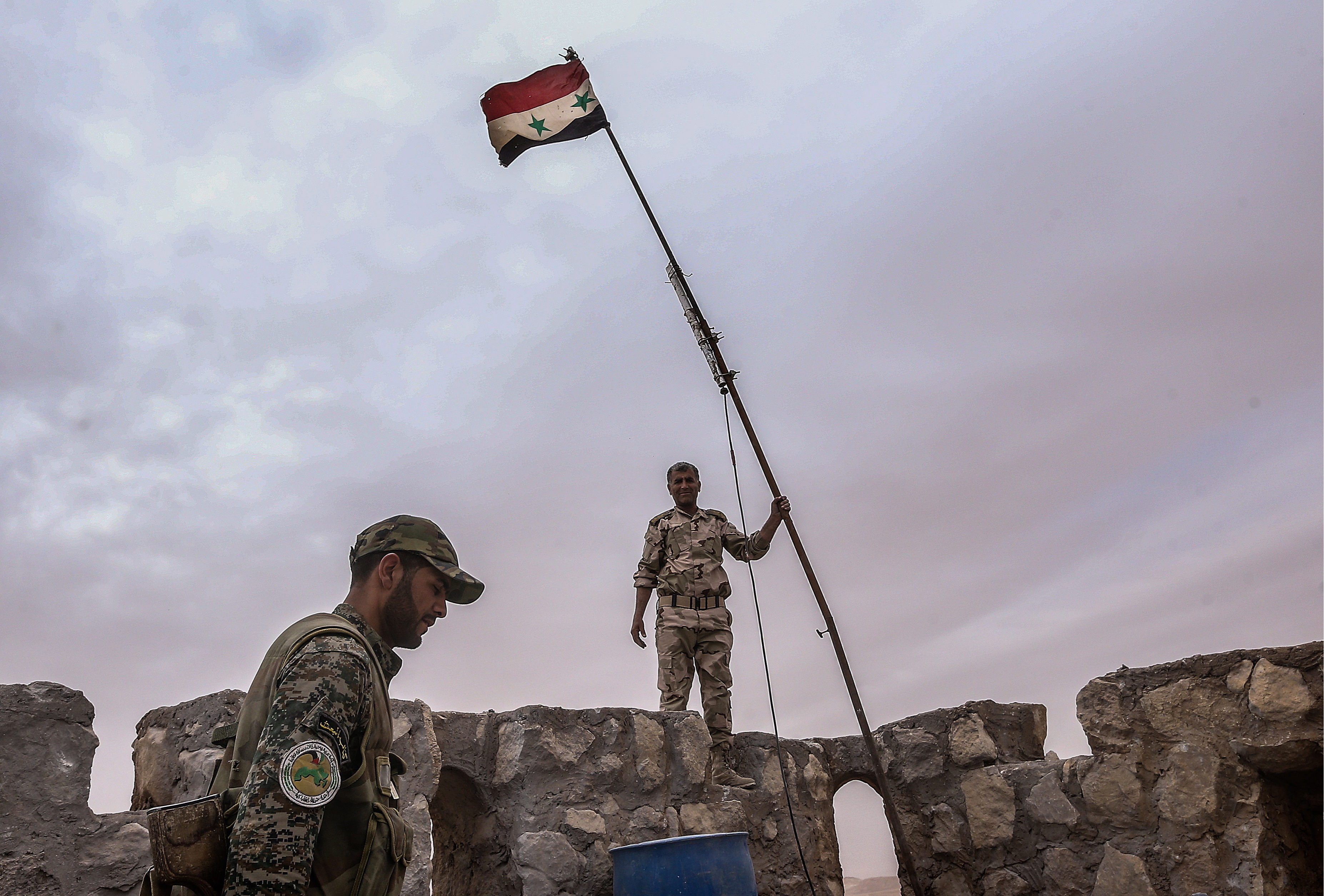 Syrian government army soldiers put a flag on top of Fakhr al-Din al-Maani Citadel, in Palmyra, Syria, on March 26, 2016. (Valery Sharifulin—TASS/Getty Images)