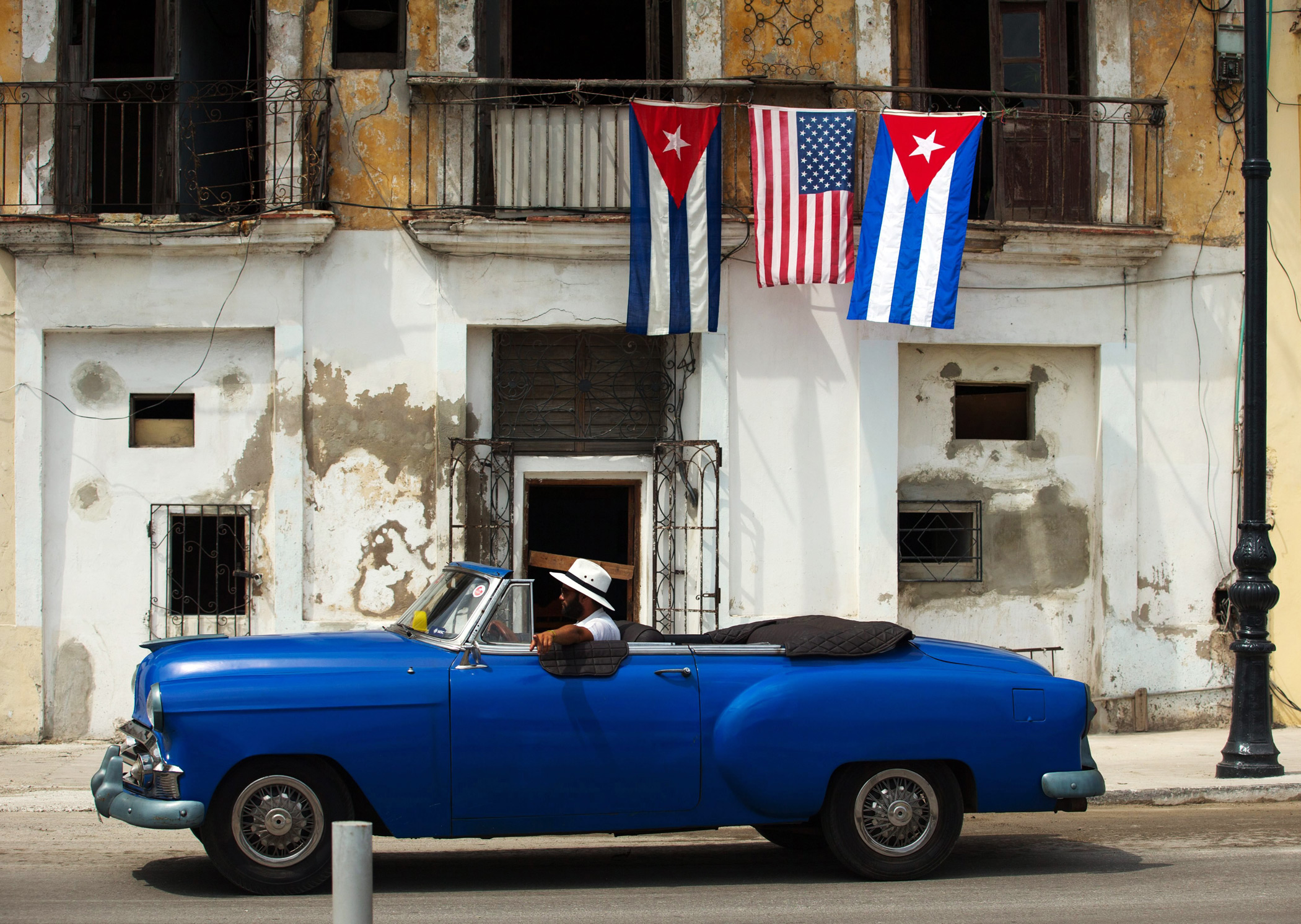 A car passes by a house decorated with the flags of the United States and Cuba in Havana, on March 20 2016.