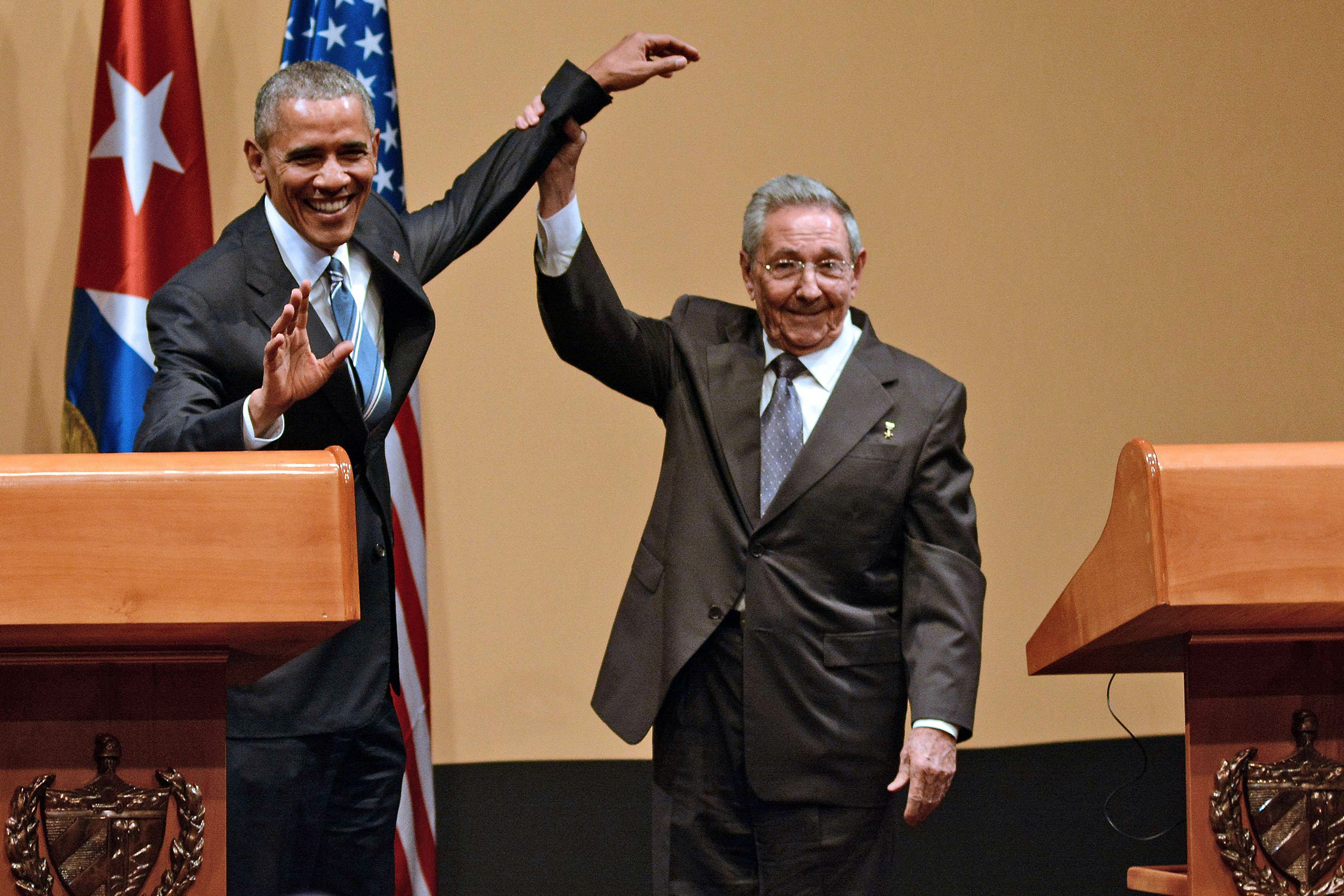 Cuban President Raul Castro, right, raises the hand of U.S. President Barack Obama during a joint press conference at the Revolution Palace in Havana on March 21, 2016.