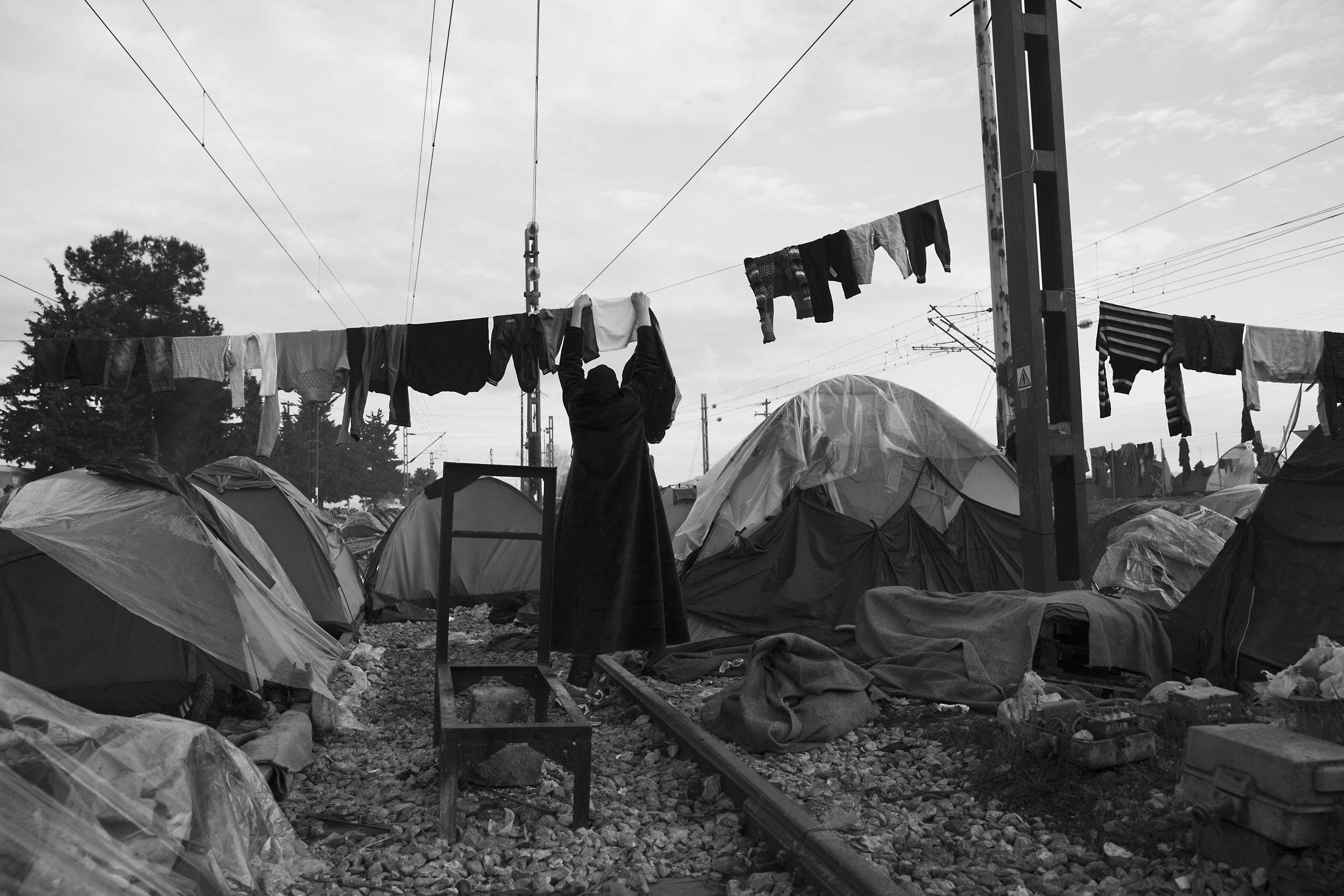A woman hangs laundry at a camp where thousands of refugees are stranded near the village of Idomeni,  Greece at the border with Macedonia, March 12, 2016.