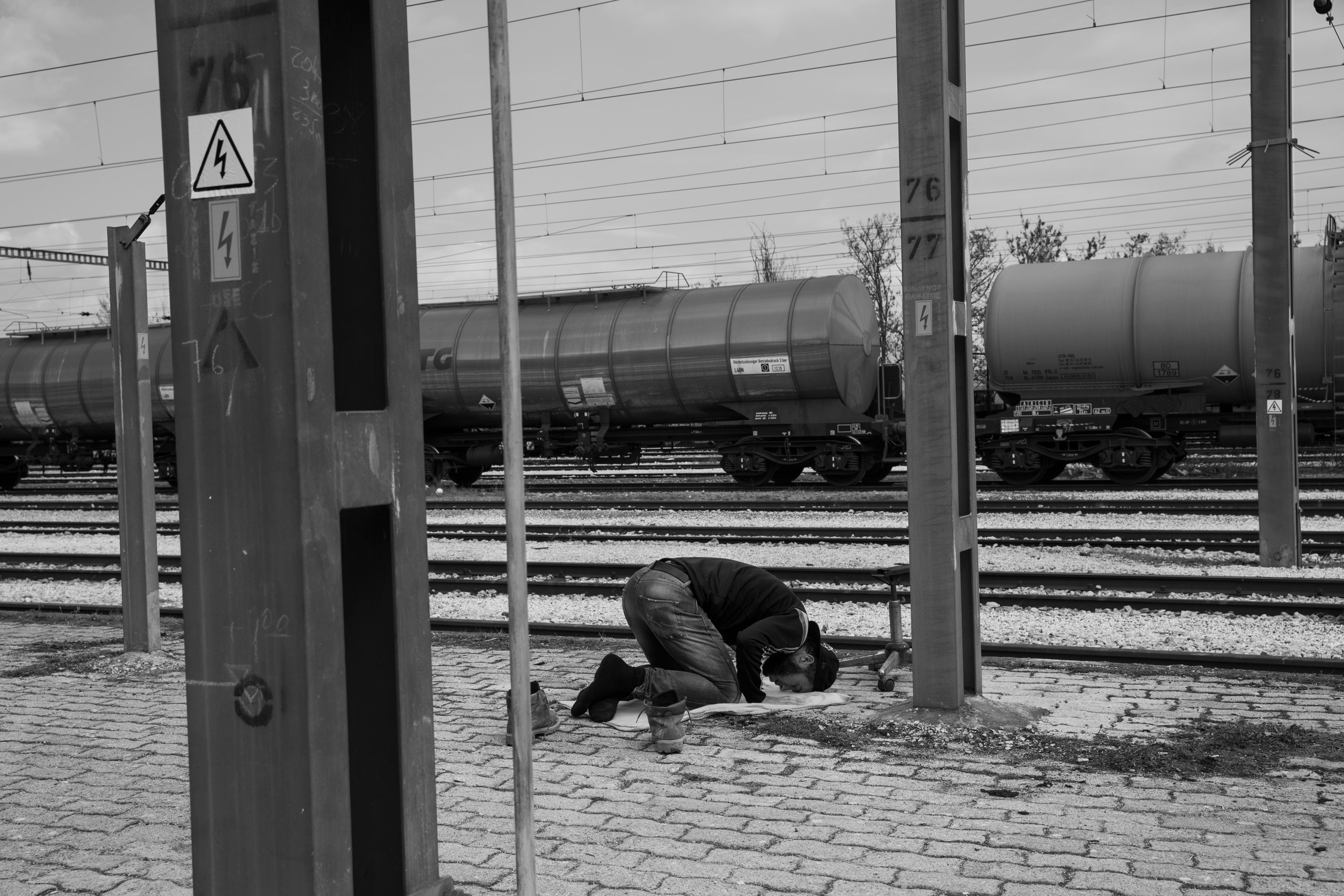 A man prays near the railroad tracks in the Idomeni refugee camp at the Greece Macedonia border, where thousands of refugees now seek shelter, as they are unable to make their way further north in Europe, March 18, 2016.