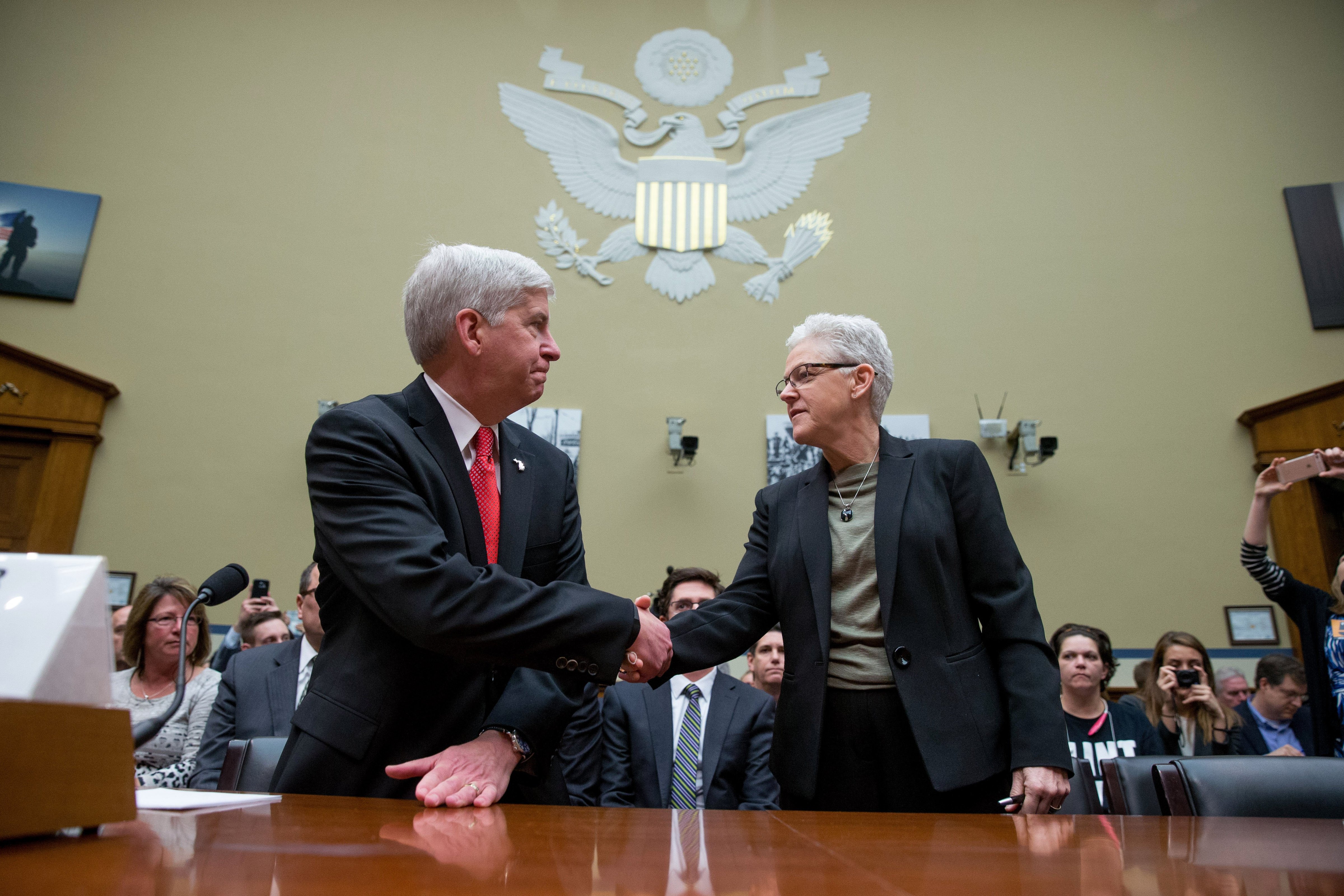 Michigan Gov. Rick Snyder and EPA Administrator Gina McCarthy greet each other as they arrive to testify before a House Oversight and Government Reform Committee hearing in Washington on March 17, 2016, to look into the circumstances surrounding high levels of lead found in many residents' tap water in Flint, Michigan. (Andrew Harnik—AP)