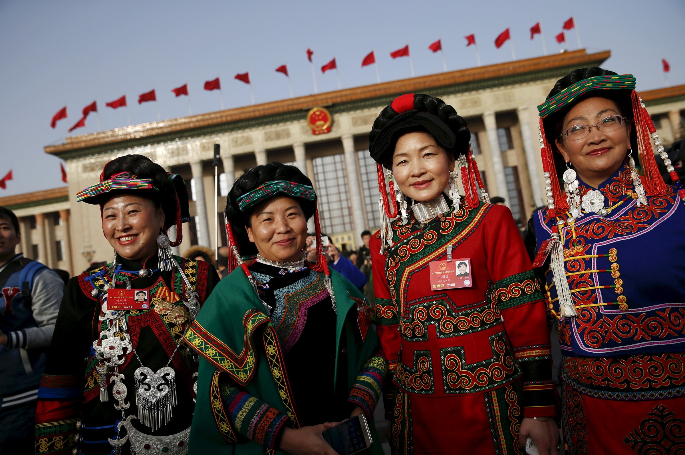 Ethnic minority delegates pose for pictures outside the Great Hall of the People ahead of the opening session of the National People's Congress in Beijing