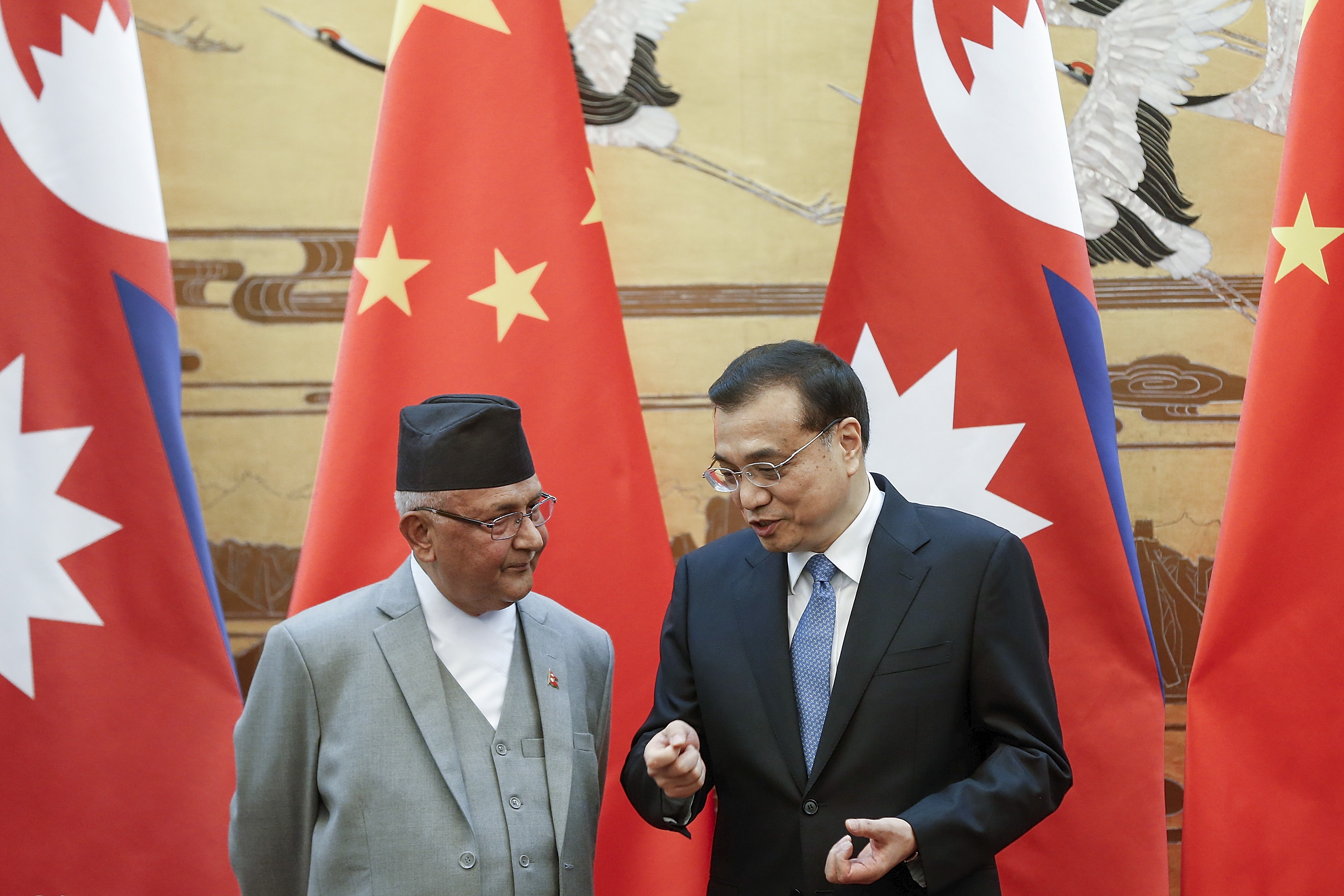 Chinese Premier Li Keqiang talks to Nepal Prime Minister Khadga Prasad Sharma Oli during a signing ceremony at the Great Hall of the People in Beijing