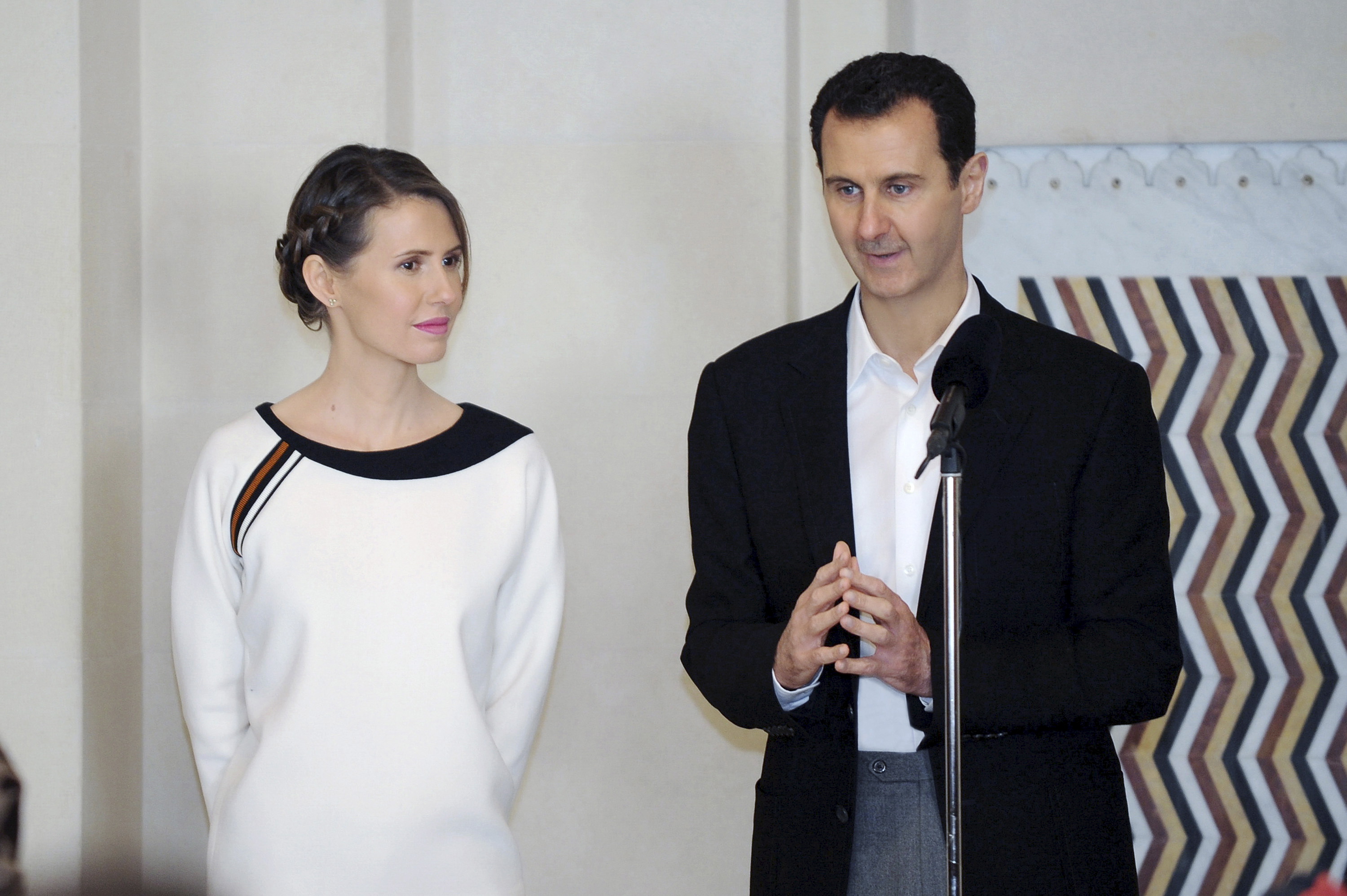 Syria's President Bashar Assad stands next to his wife Asma as he addresses injured soldiers and their mothers during a celebration marking Syrian Mother's Day in Damascus, in this handout picture provided by SANA on March 21, 2016 (Sana—Reuters)