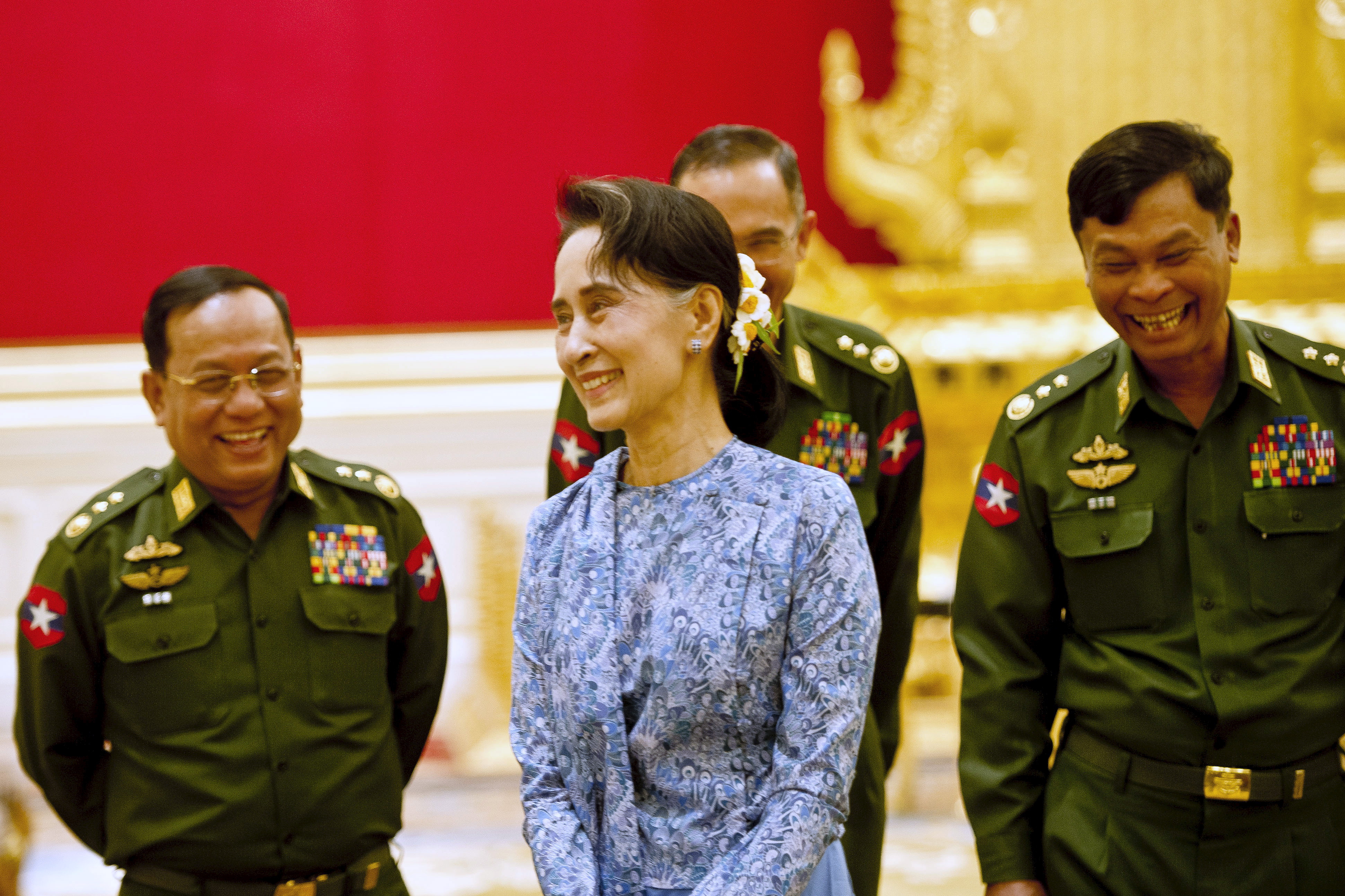 Myanmar's NLD party leader Aung San Suu Kyi smiles with army members during the handover ceremony of outgoing President Thein Sein and new President Htin Kyaw at the presidential palace in Naypyitaw