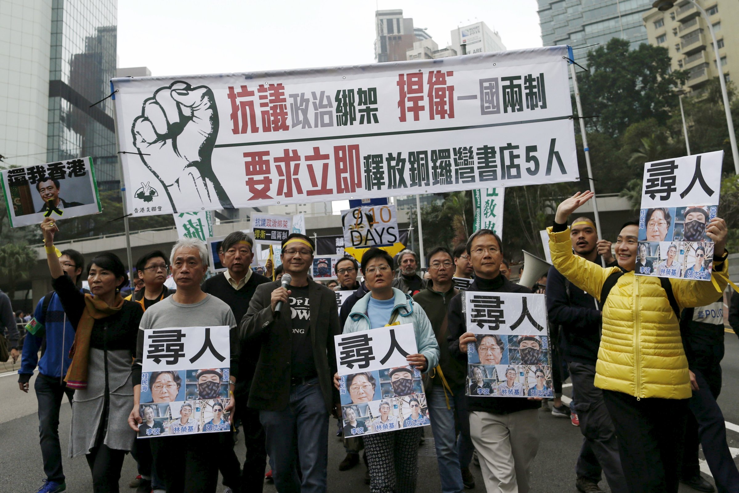 Demonstrators hold up portraits of five missing staff members of a publishing house and a bookstore during a protest over the disappearance of booksellers, in Hong Kong, China