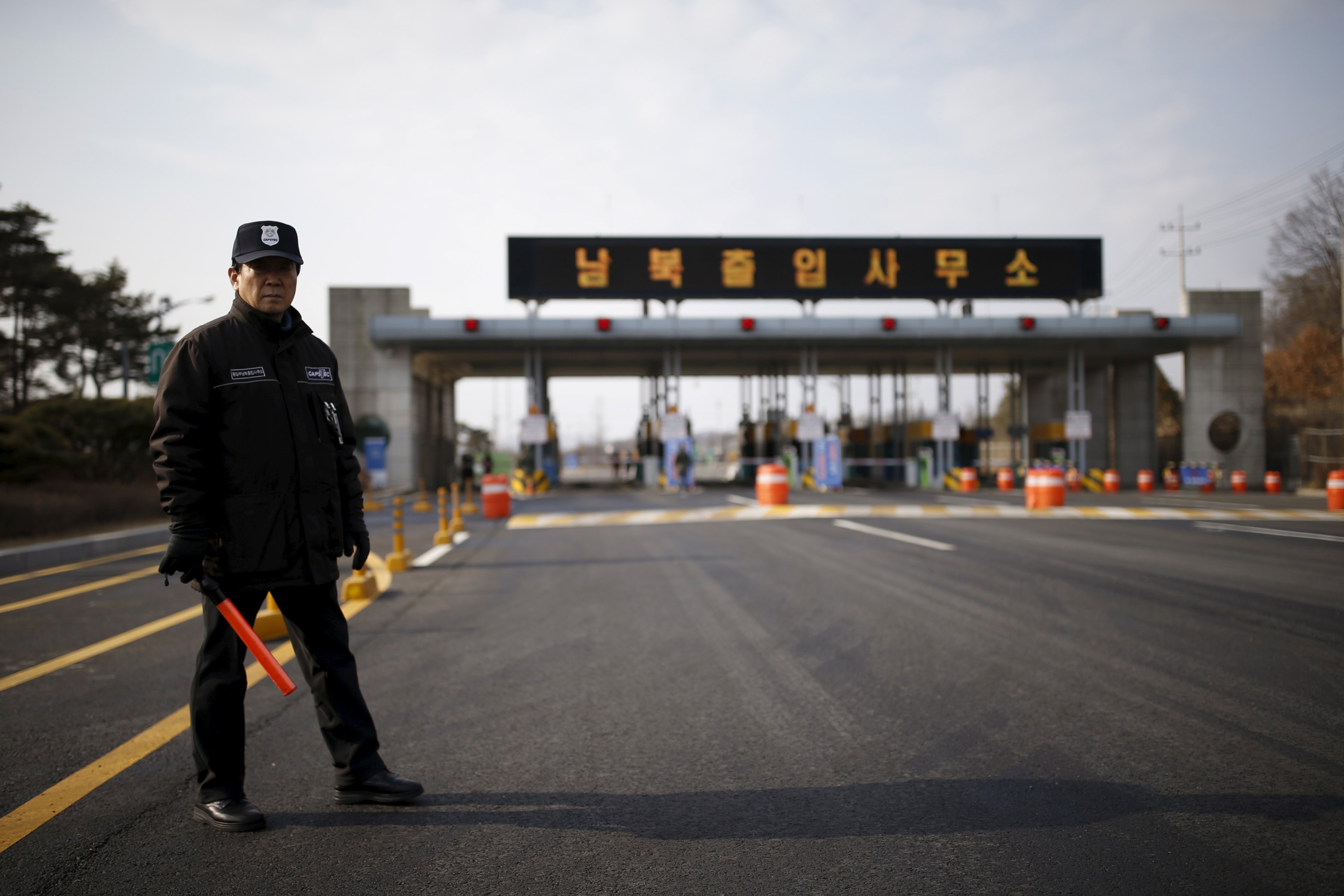 A South Korean security guard stands guard on an empty road that leads to the Kaesong Industrial Complex at the South's Customs, Immigration and Quarantine, just south of the demilitarized zone separating the two Koreas, in Paju, South Korea, on Feb. 11, 2016 (Kim Hong-Ji—Reuters)