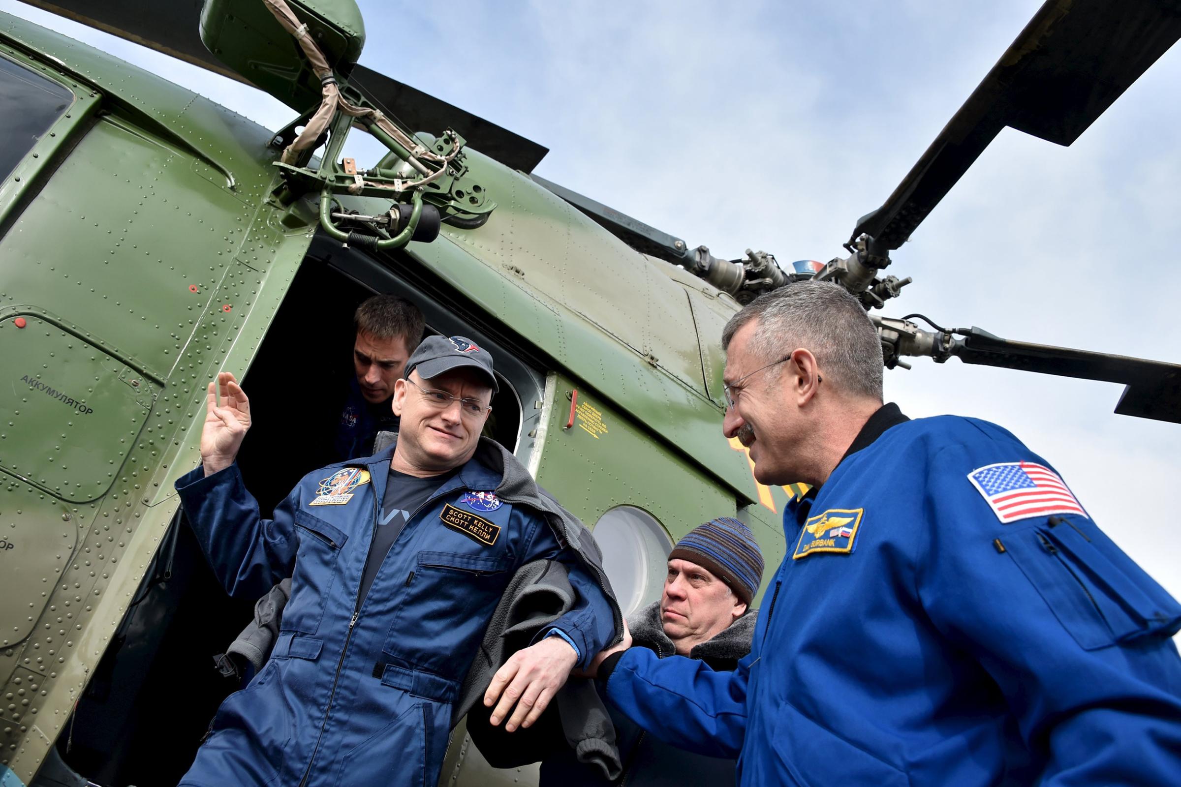 Members of NASA support team help Scott Kelly get off a helicopter at an airport in Zhezkazgan, Kazakhstan on March 2, 2016.