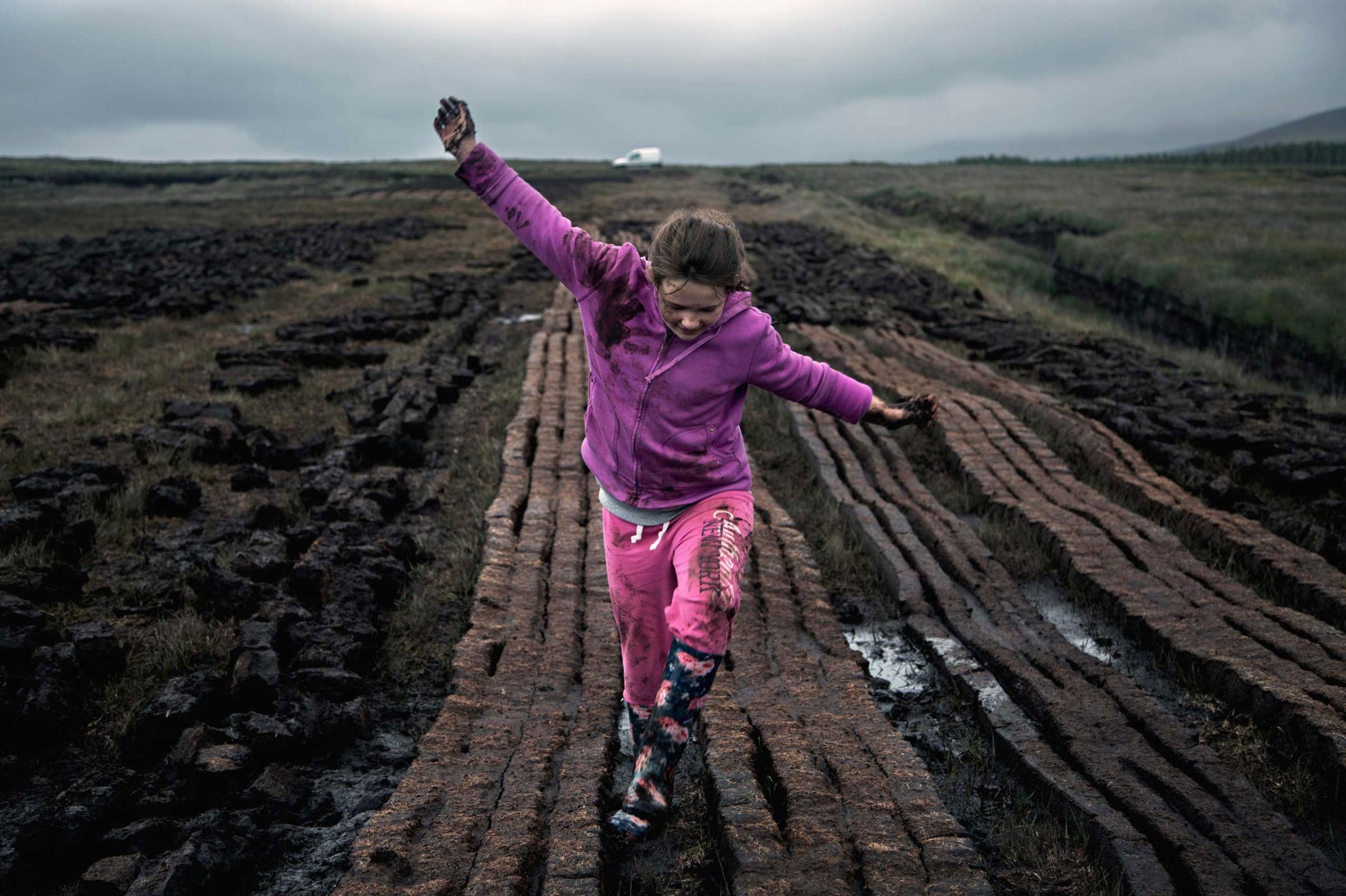 Ballycroy. Co. Mayo A young girl in a bog she and her father have been working, known locally as turf cutting. Recently enacted European Union regulations, as well as Irish law, ban the collection of turf from 53 peat-bog conservation areas, despite the centuries-old tradition of burning peat as a heat source.