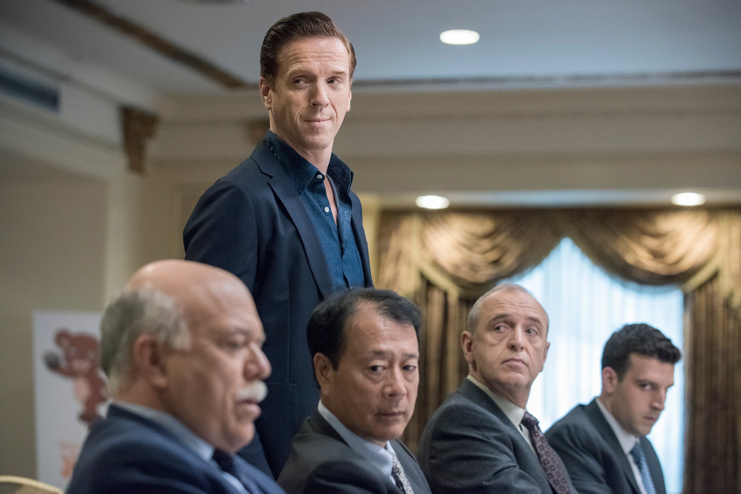 Damian Lewis, standing, plays the rapacious hedge funder Bobby “Axe” Axelrod in Billions