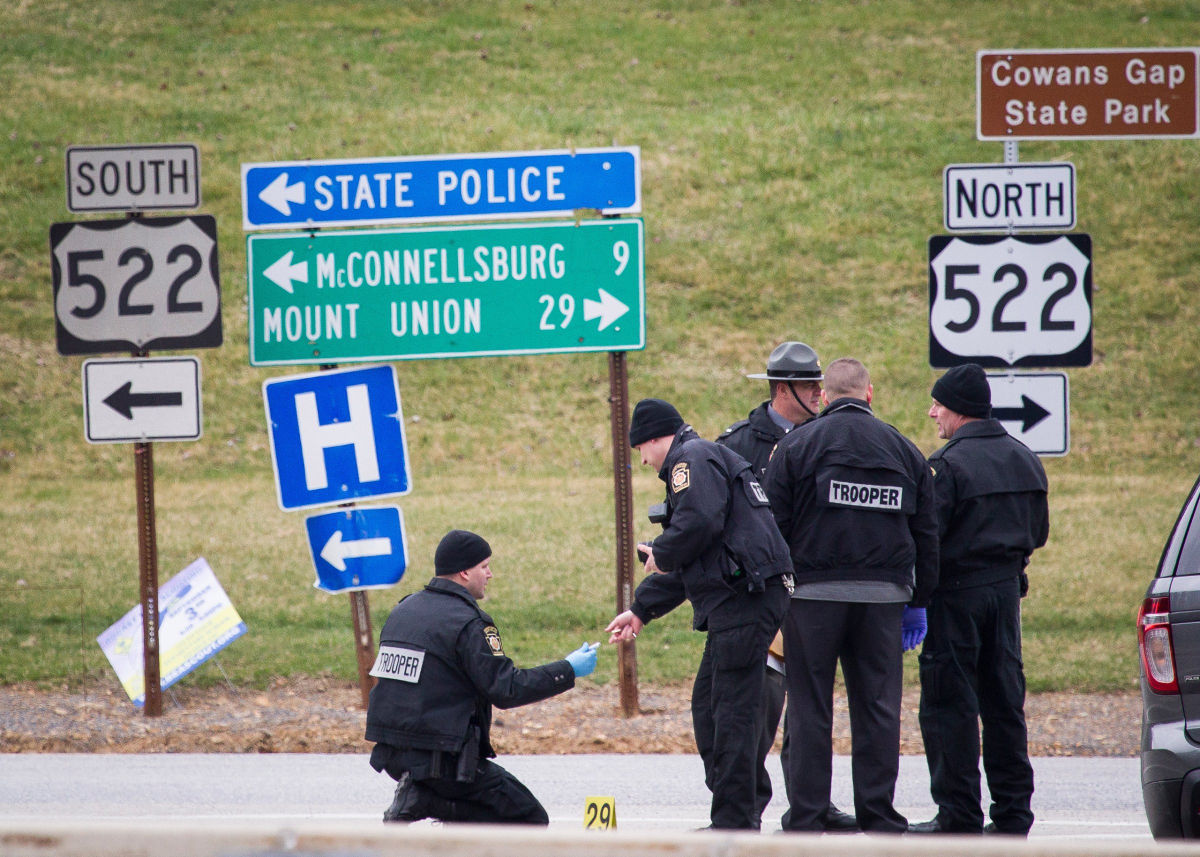Police investigate at exit 180 off of the Pennsylvania Turnpike, Sunday, March 20, 2016, in Fort Littleton, Pa. A retired state trooper killed a turnpike toll collector and a security guard in a holdup attempt at a toll plaza and then was shot dead by troopers while trying to escape with the money, authorities said. (Daniel Zampogna/PennLive.com via AP) MANDATORY CREDIT; MAGS OUT