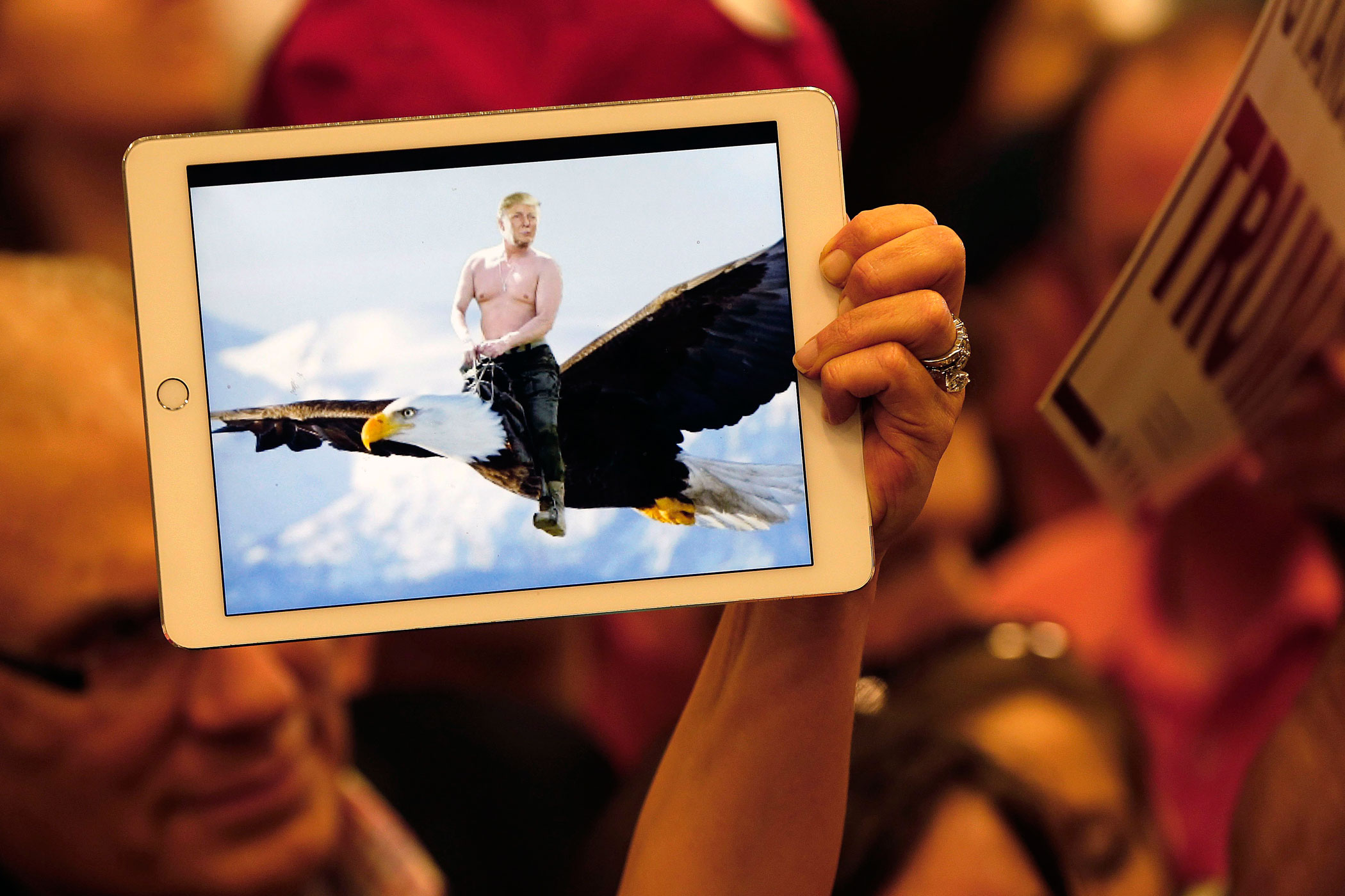 A supporter of Republican presidential candidate Donald Trump holds up an illustration of him riding shirtless on the back of a Bald Eagle, as he greets the crowd after speaking at a campaign rally in New Orleans, on March 4.