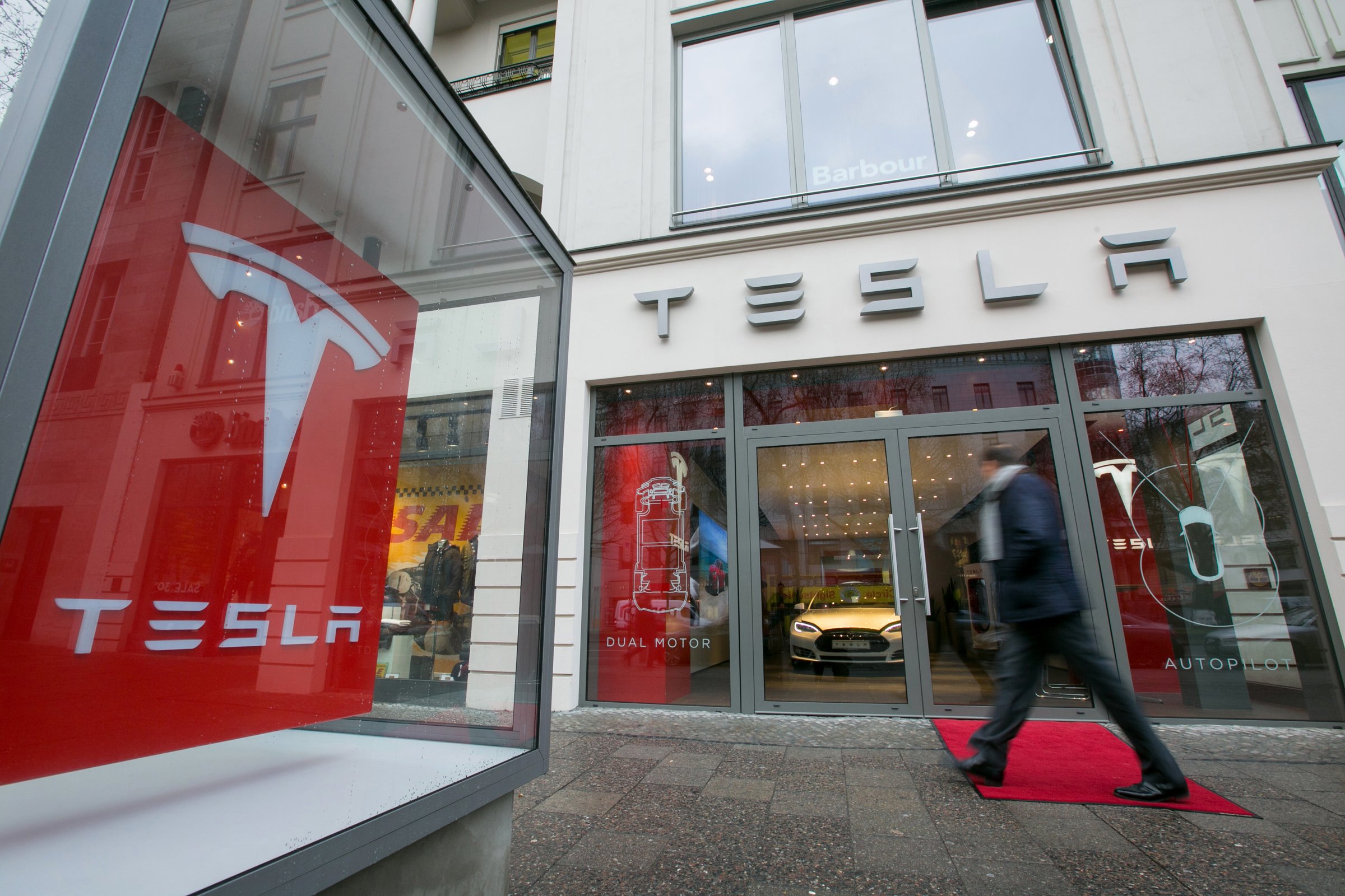 A pedestrian passes a Tesla Motors Inc. electric automobile showroom in Berlin, Germany, on Wednesday, Jan. 7, 2015.