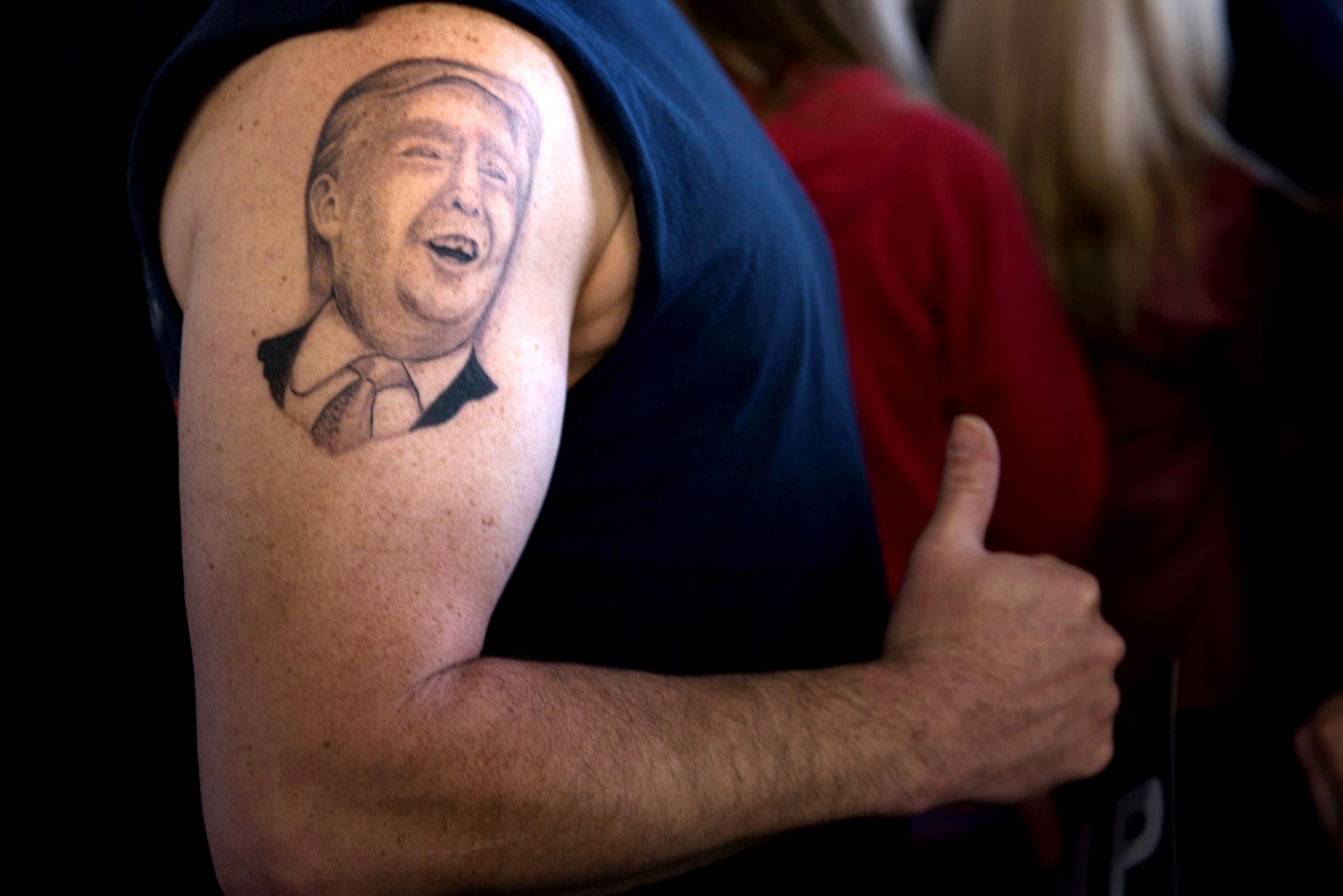 Anthony Borbell shows off his tattoo, a likeness of Donald Trump, during a rally on March 14 in Vienna Center, Ohio.