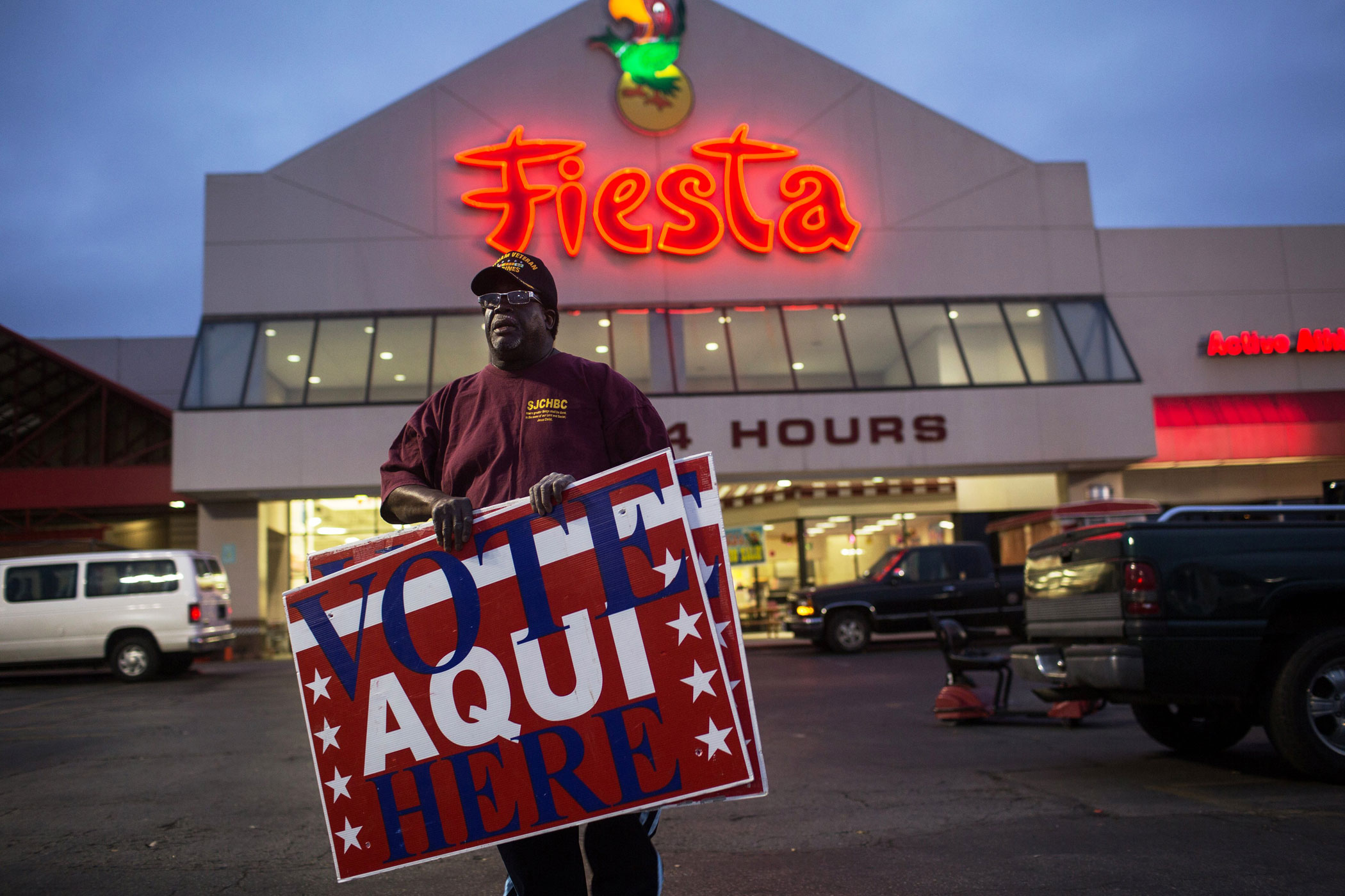 Volunteer election clerk Allie Green Jr. searches for places to post voting signs outside of supermarket polling location in Austin, Texas on Tuesday.