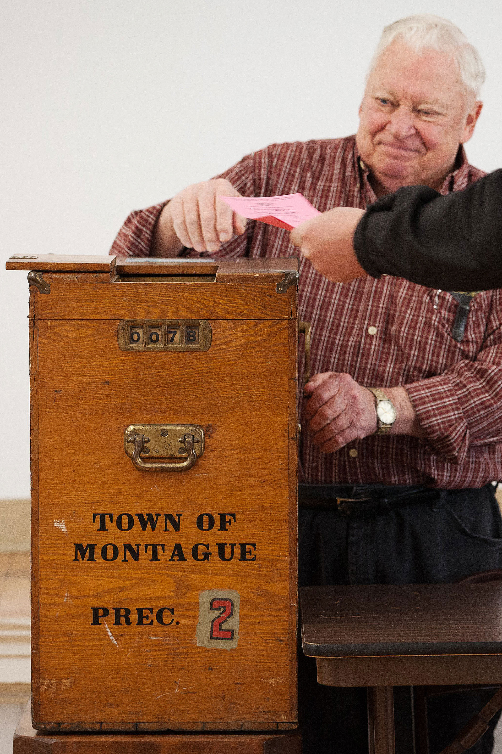 Poll worker John Mayrand mans a manual, crank operated ballot box on March 1 in Montague, Mass.