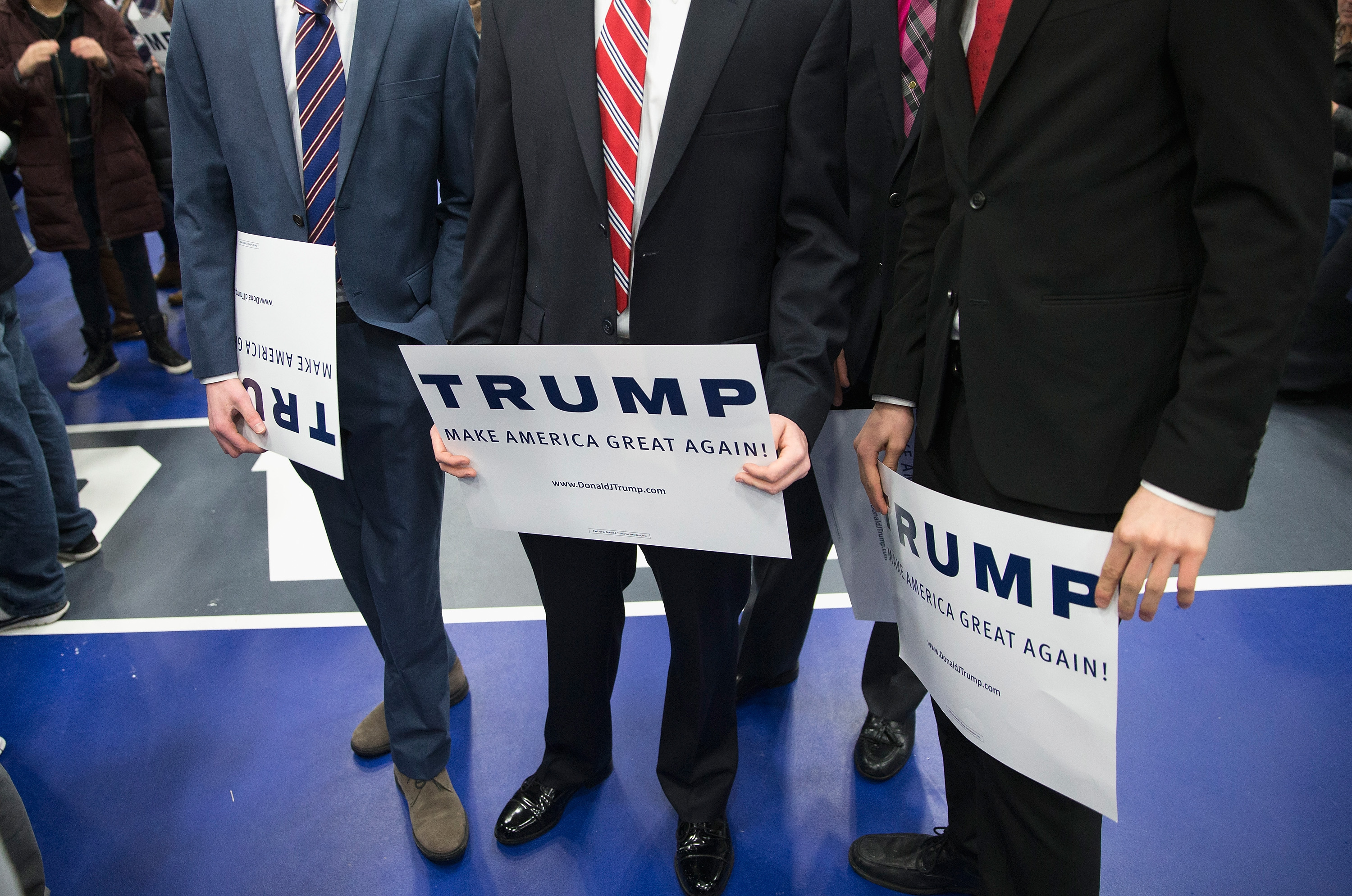 Men hold signs while waiting for Republican presidential candidate Donald Trump to arrive for a rally at Macomb Community College in Warren, Mich., on March 4, 2016. (Scott Olson—Getty Images)
