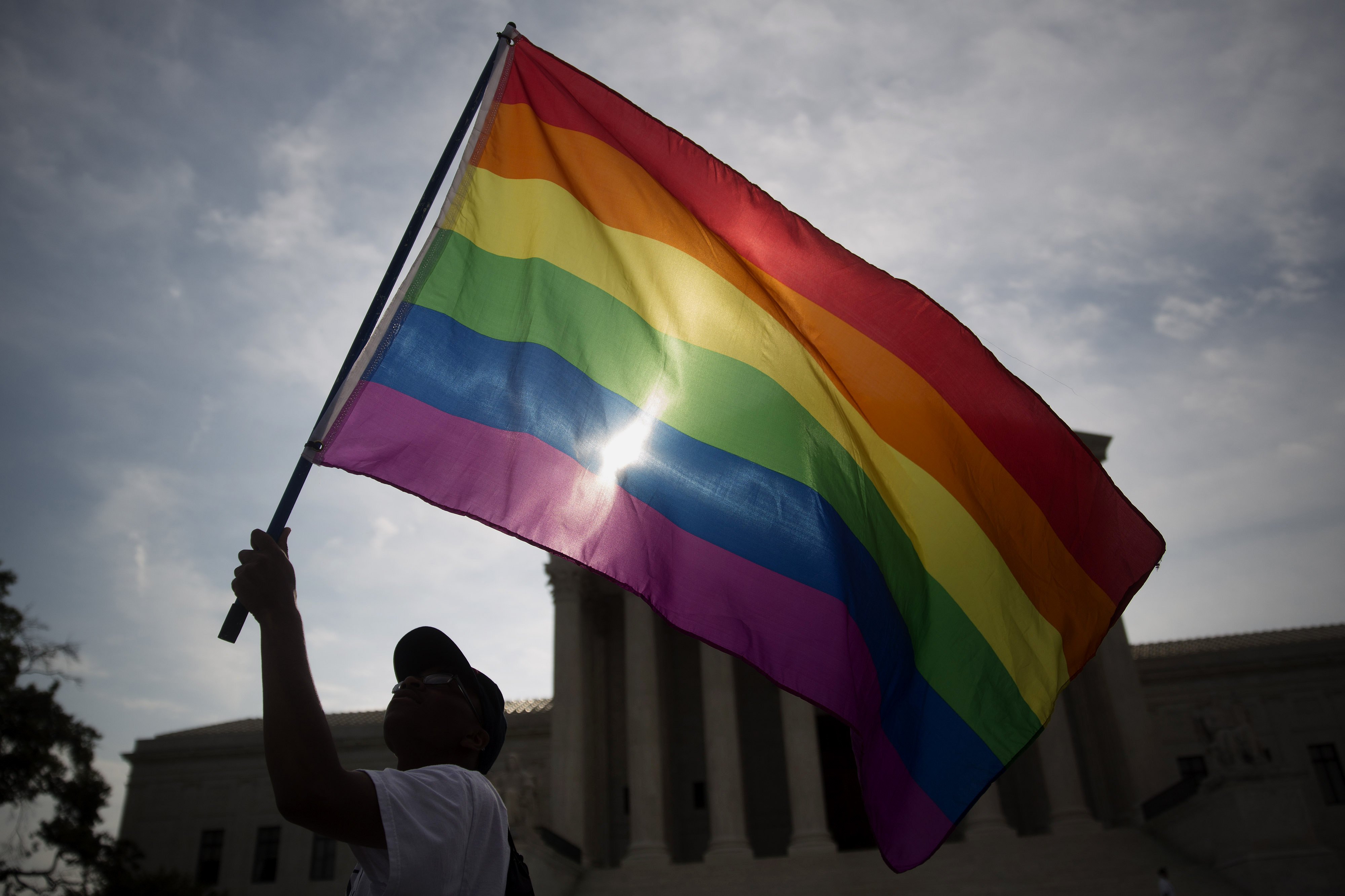 Carlos McKnight, from Washington, D.C., waves a rainbow colored flag outside the U.S. Supreme Court in Washington, D.C., U.S., on Friday, June 26, 2015. (Andrew Harrer— 2015 Bloomberg Finance LP/Getty Images)