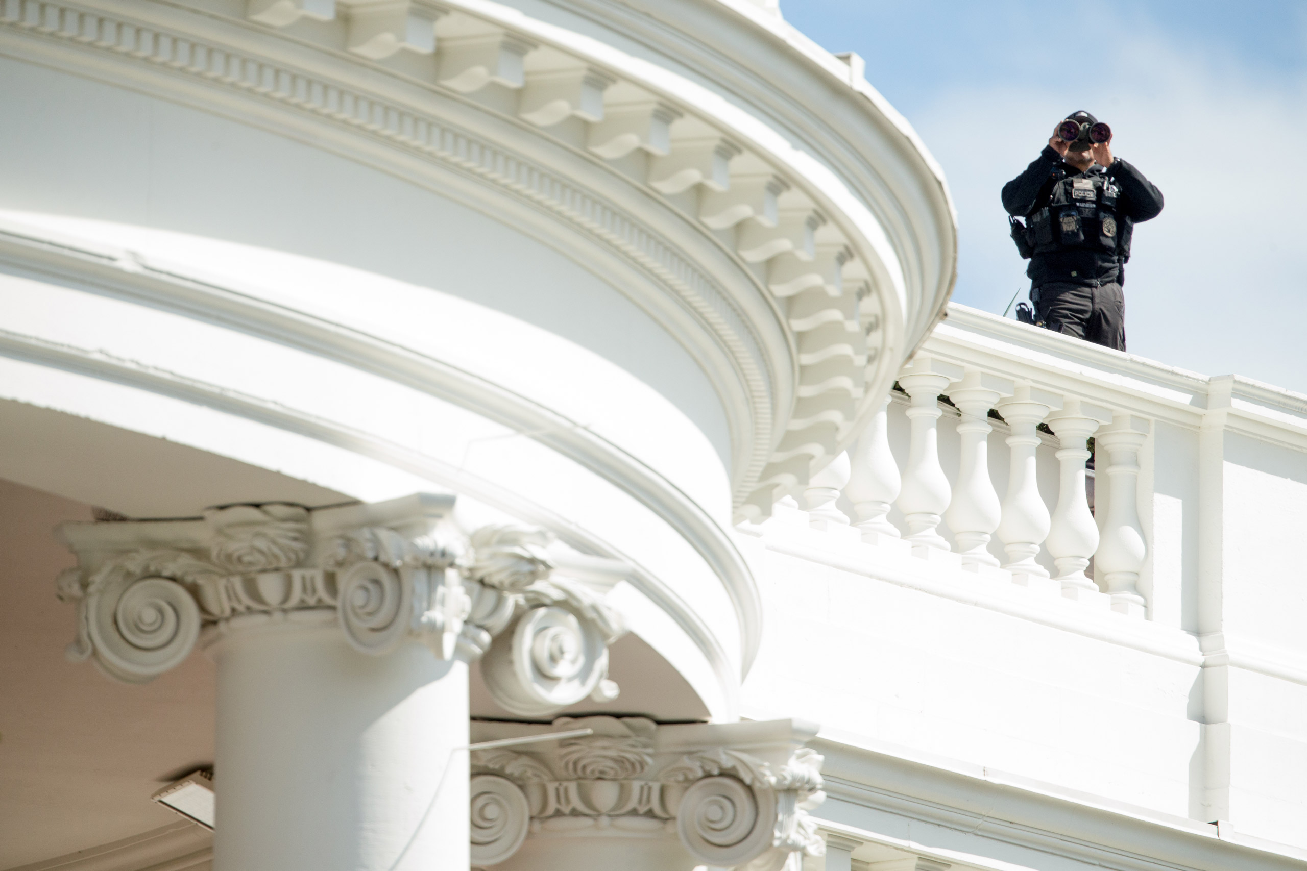A member of the Secret Service stands on the roof of the White House during the White House Easter Egg Roll on the South Lawn in Washington, Monday, March 28, 2016. Thousands of children gathered at the White House for the annual Easter Egg Roll. This year's event features  live music, sports courts, cooking stations, storytelling, and Easter egg rolling. (AP Photo/Andrew Harnik)