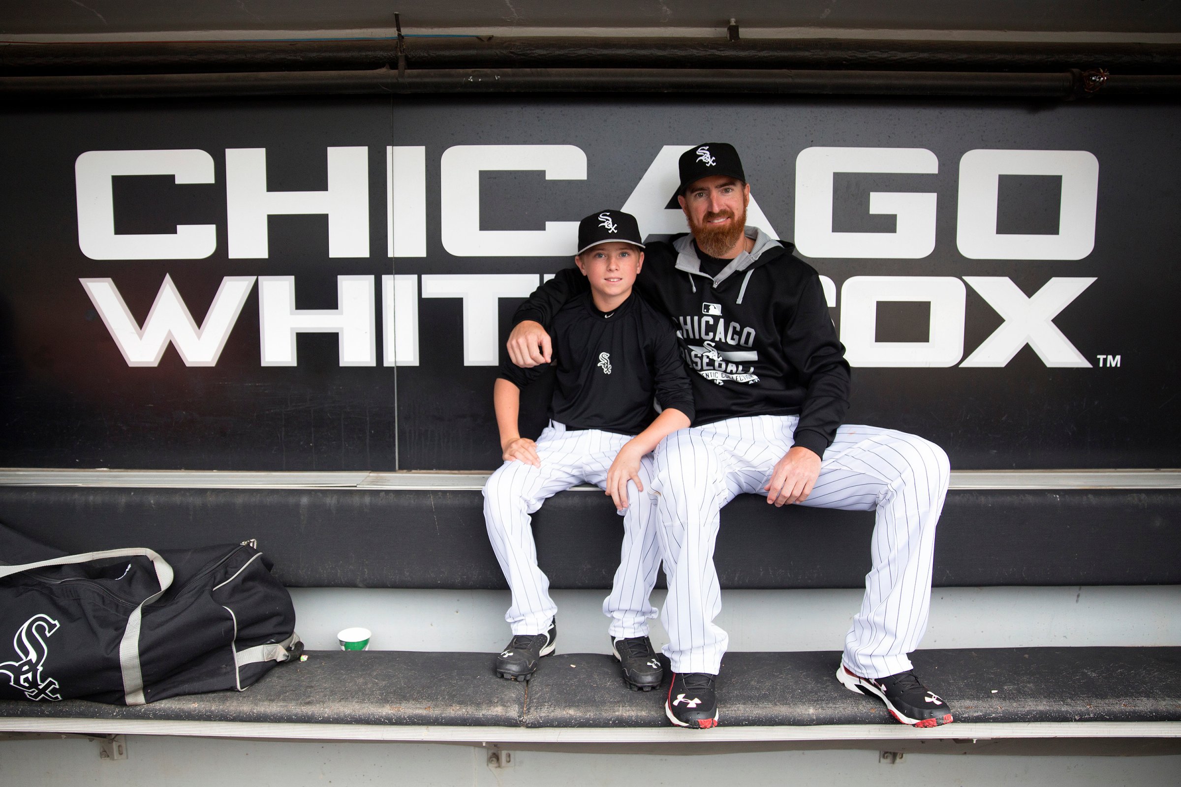 Chicago White Sox designated hitter Adam LaRoche (25) sits with his son Drake, 13, in the White Sox dugout at U.S. Cellular Field before a game against the Houston Astros on June 8, 2015 in Chicago.
