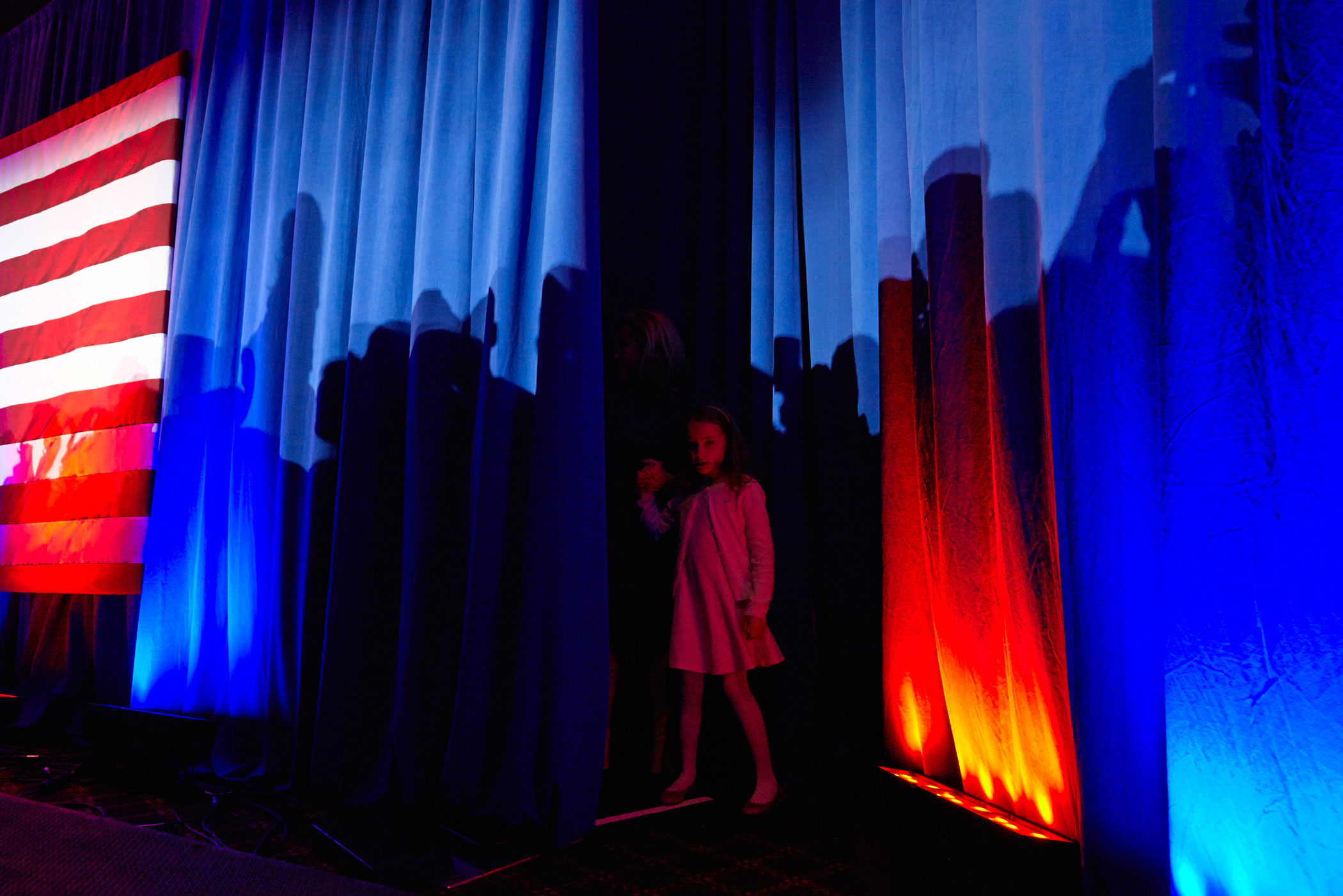 Republican presidential candidate Ted Cruz's daughter peers out from a curtain during the Texas Senator's primary night campaign event on April 5, 2016, in Milwaukee.