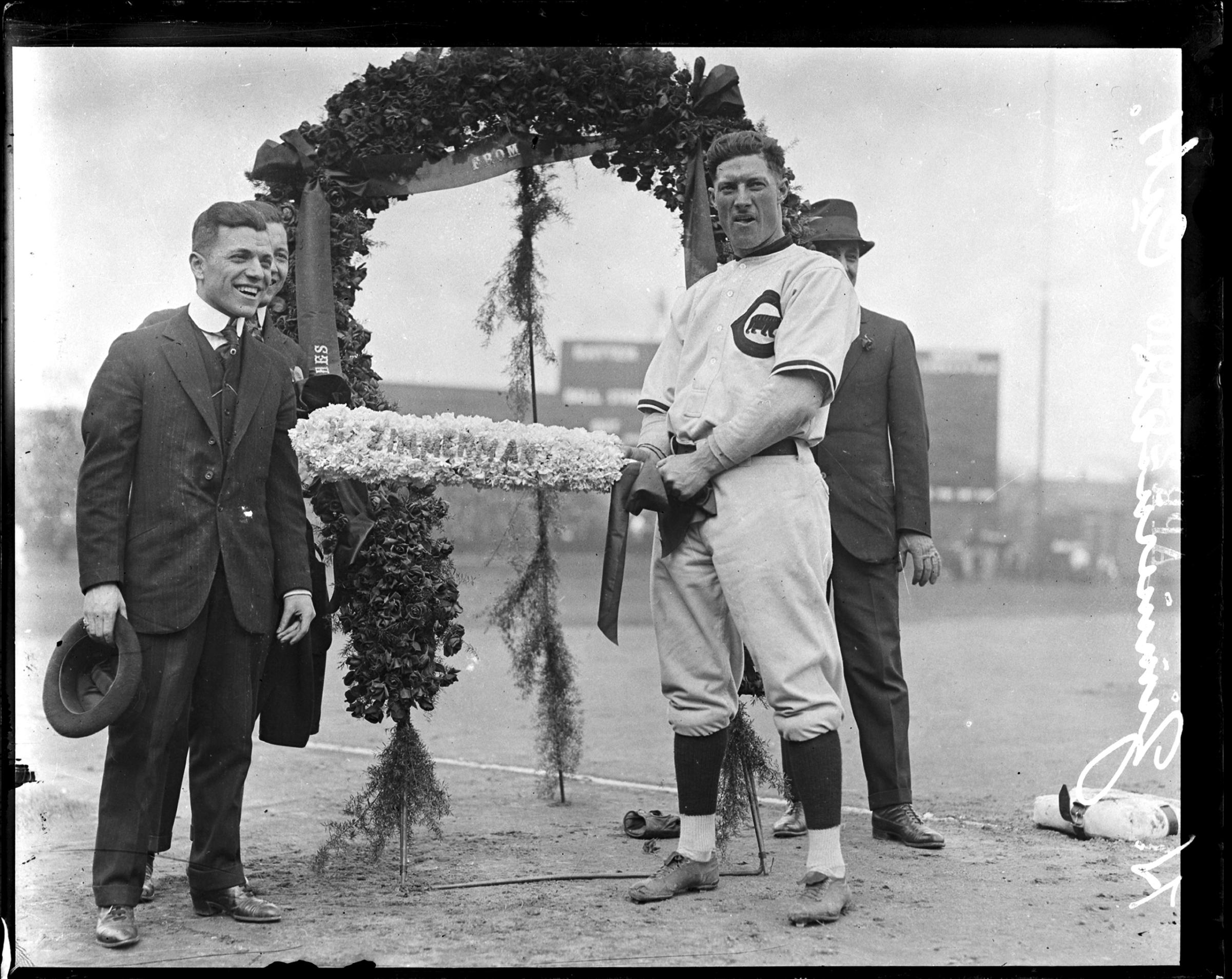 National League's Chicago Cubs baseball player Heinie Zimmerman standing in front of a floral arch at Weeghman Park, Chicago, Illinois, 1916.