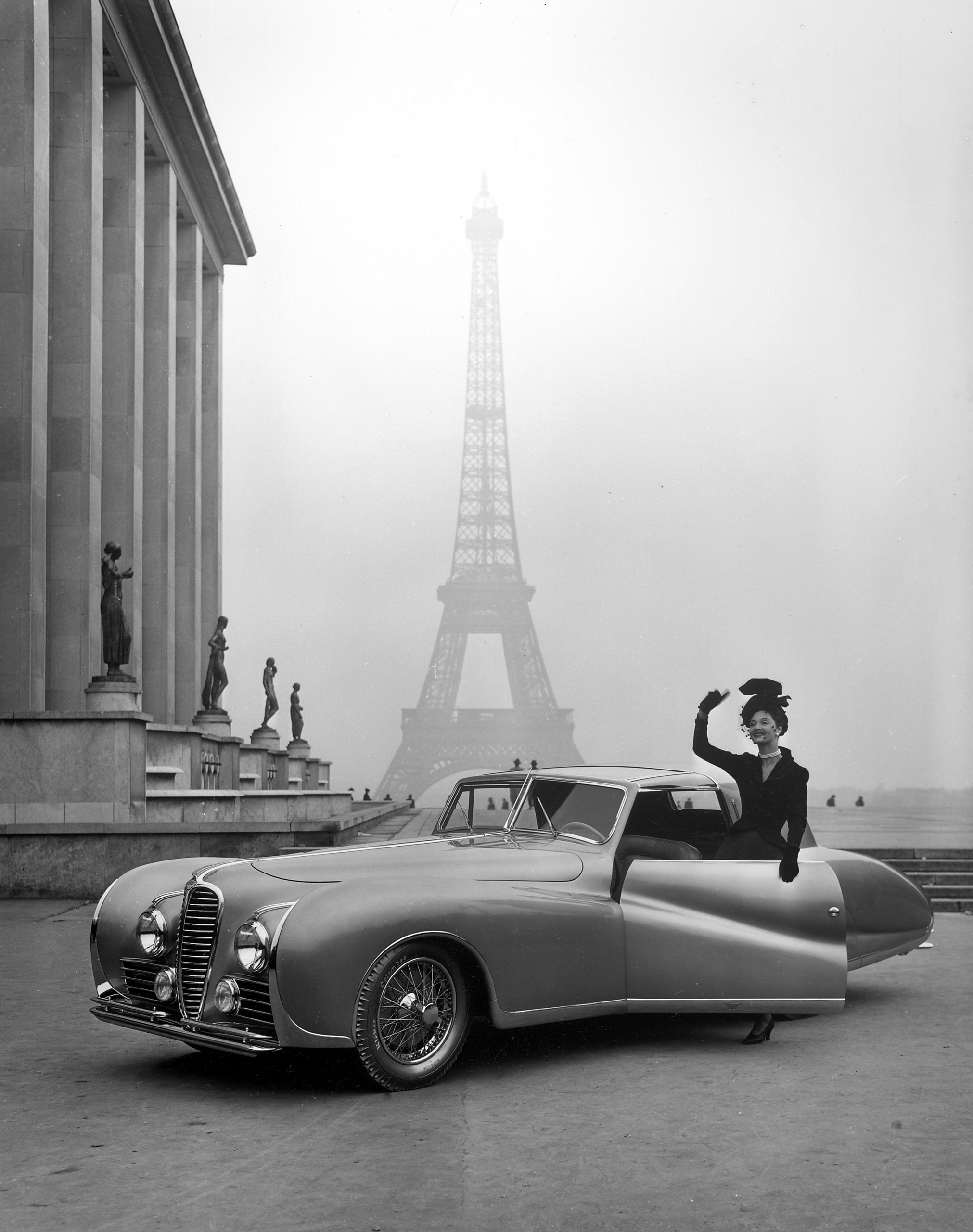 Model wearing Jacques Fath posing beside a Delahaye, 1947.