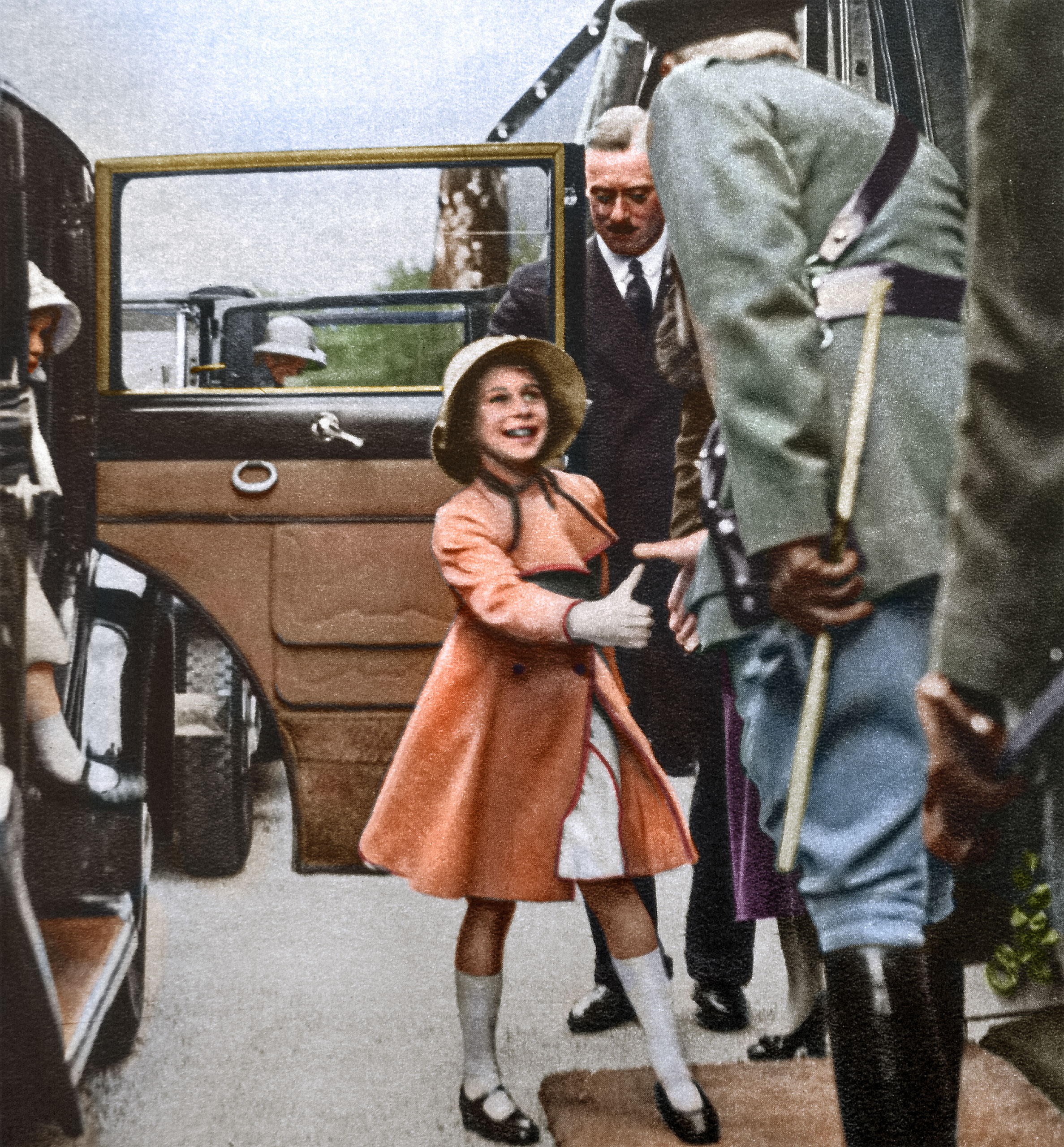 The Duchess of York took the children to see a daylight dress rehearsal of the Aldershot Tattoo. Here Princess Elizabeth greets the officer of the guard while Princess Margaret alights from the car at Rushmoor Arena. January 1935.