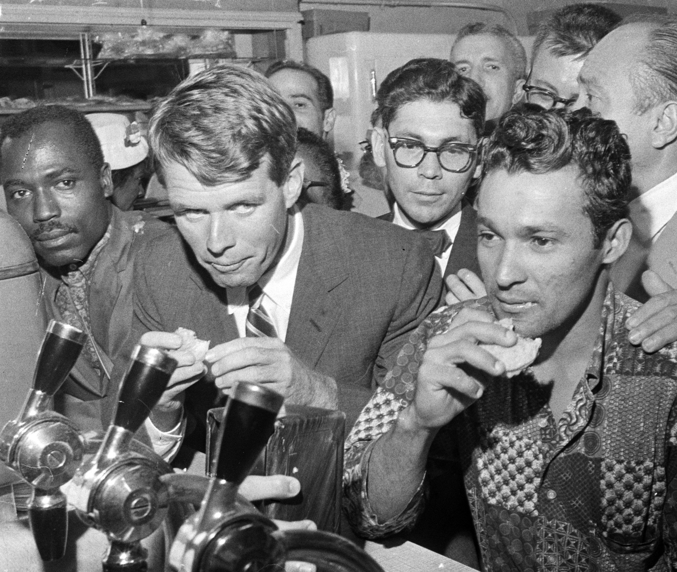 Robert Kennedy, managing his brother's presidential campaign, stops for a snack at a restaurant in Spanish Harlem. August 25, 1960.