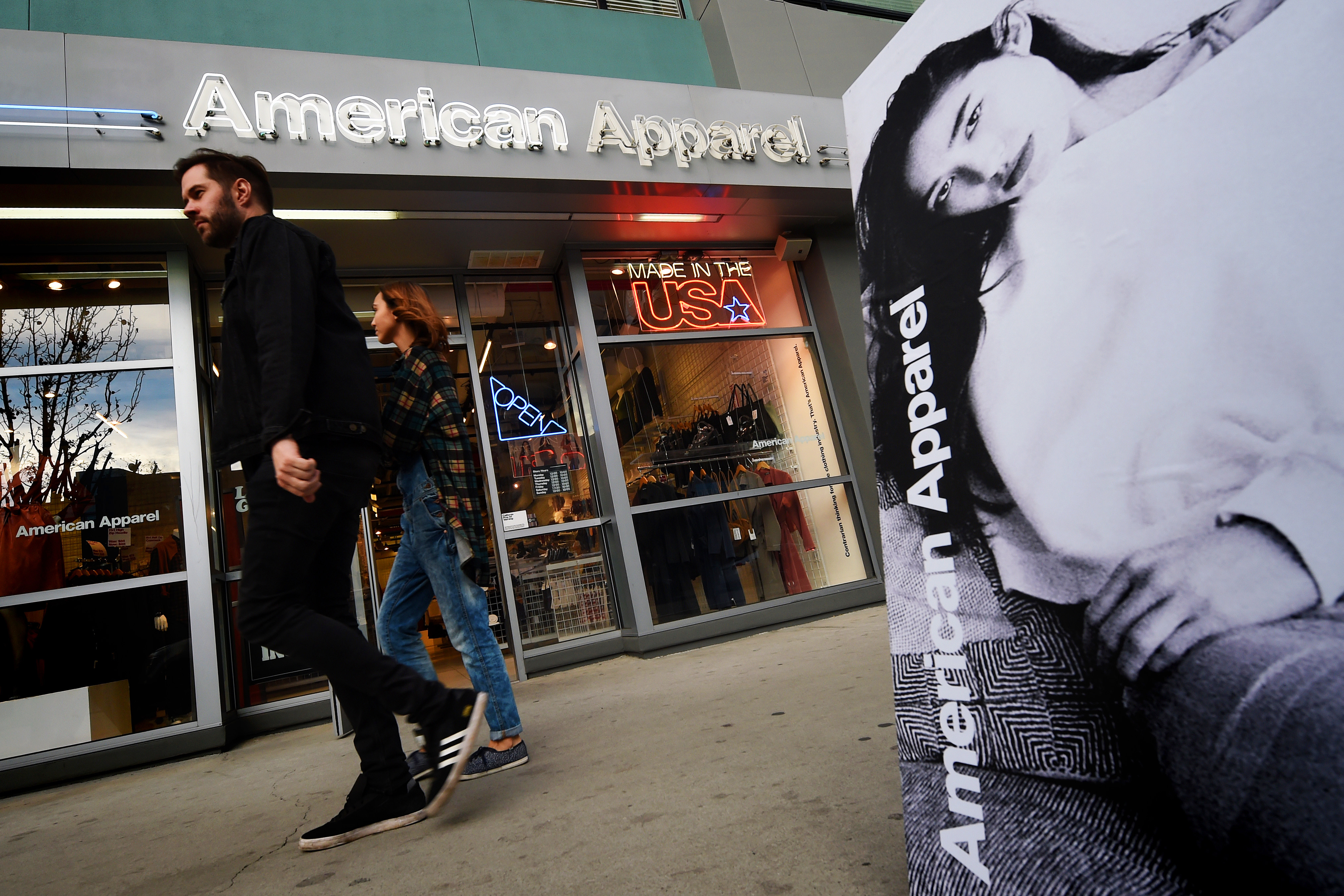 People walk past an American Apparel store in downtown Los Angeles on Jan. 27, 2016. (Mark Ralston—AFP/Getty Images)