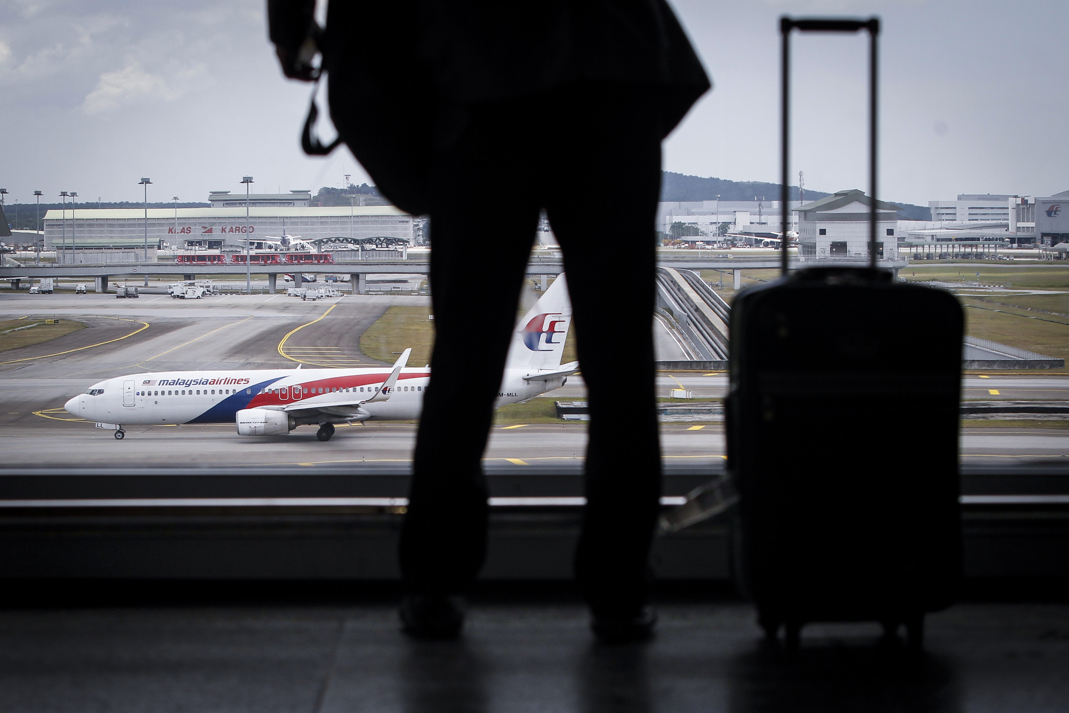 A traveller is silhouetted against a Malaysia Airlines plane at the Kuala Lumpur International Airport in Sepang, Malaysia, Tuesday, March 8, 2016. (Joshua Paul—AP)