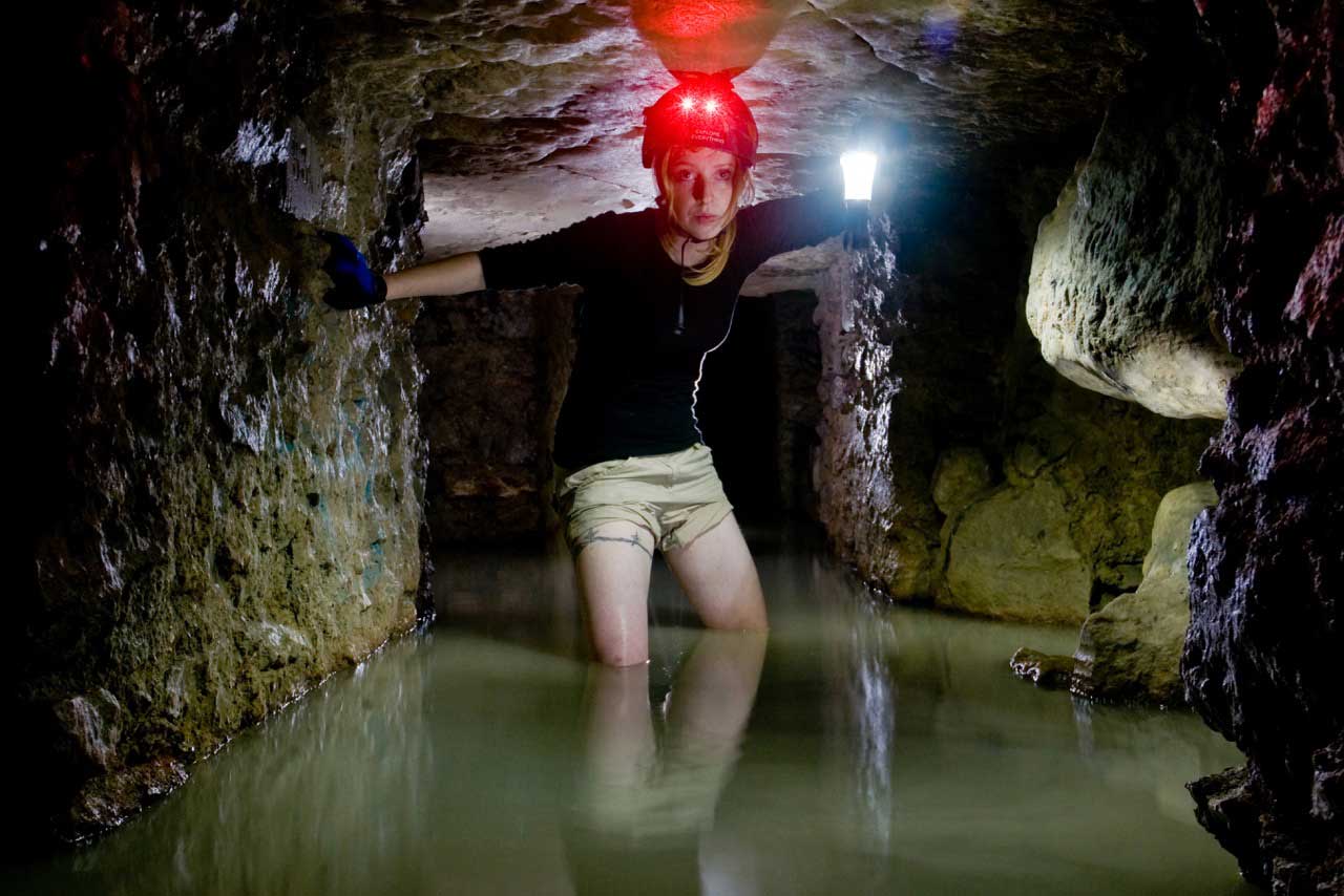 Helen  makes her way through a flooded section of the Paris catacombs, hundreds of miles of tunnels carved through the city's limestone.