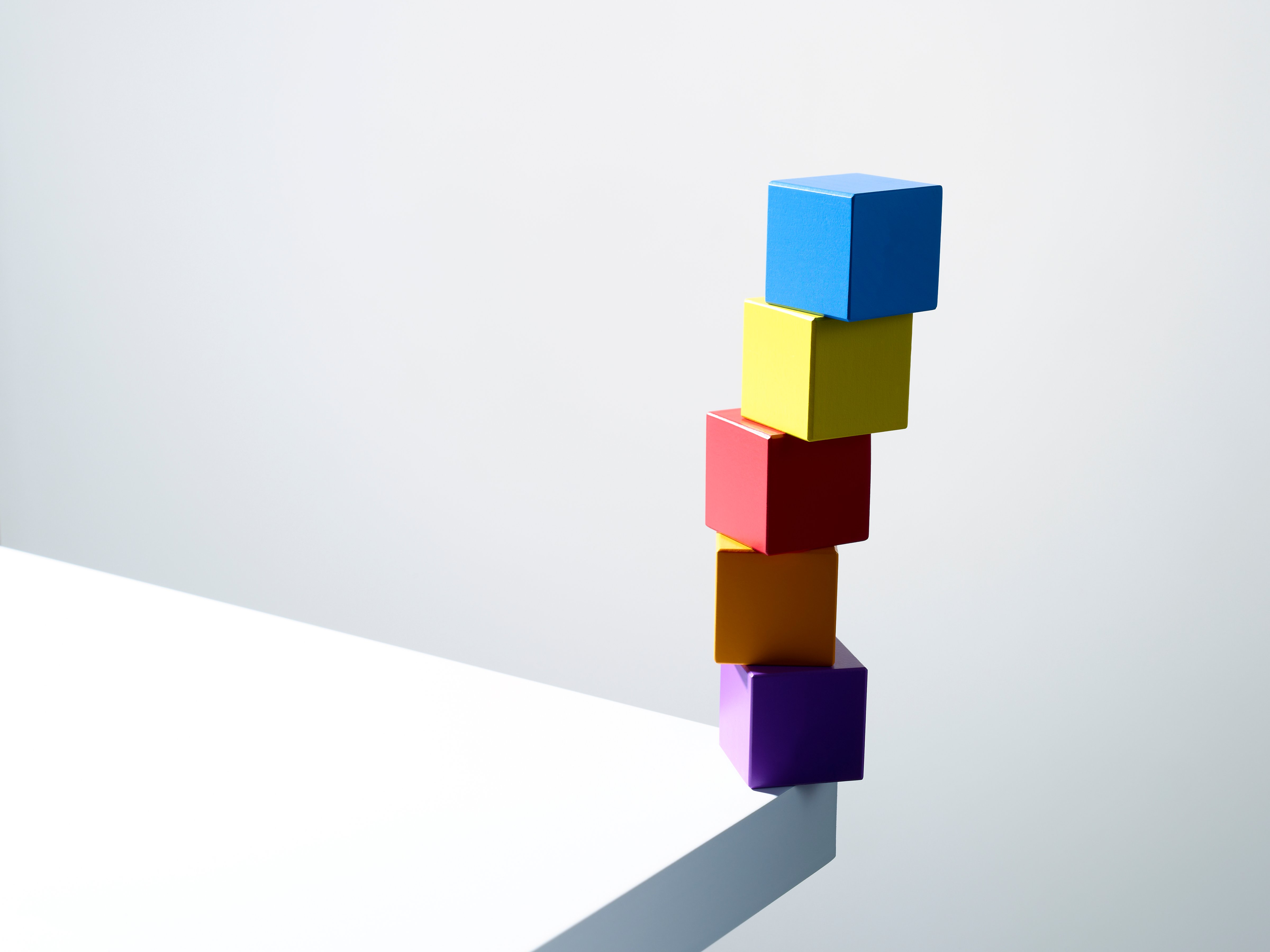 Stack of colorful cubes on table corner (Andy Roberts—Getty Images/OJO Images RF)