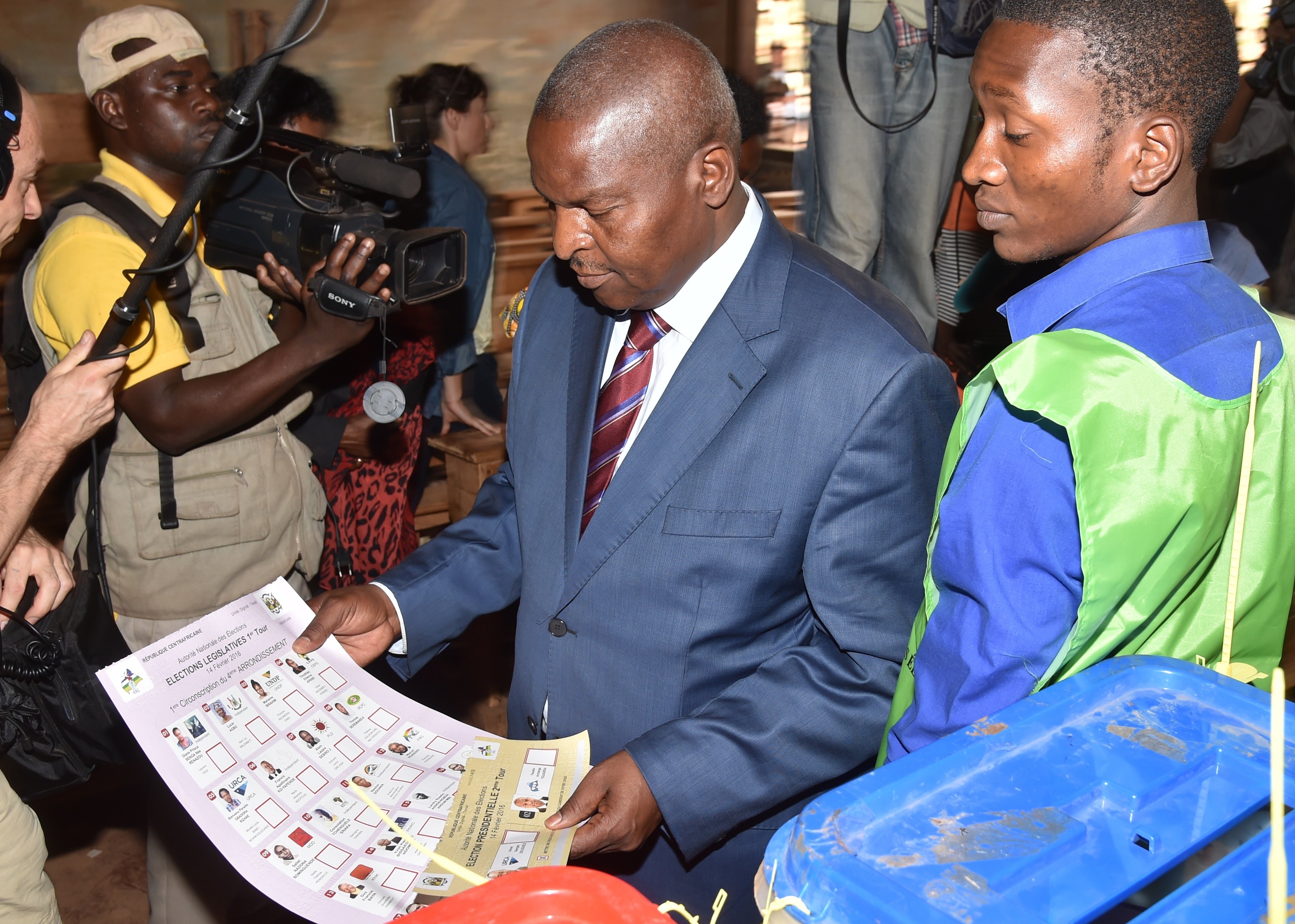 Central African Republic second round presidential candidate Faustin Archange Touadera (C) looks at a ballot before voting for delayed legislative elections and a presidential run-off, at a polling station in Bangui, on Feb. 14, 2016. (Issouf Sanogo—AFP/Getty Images)