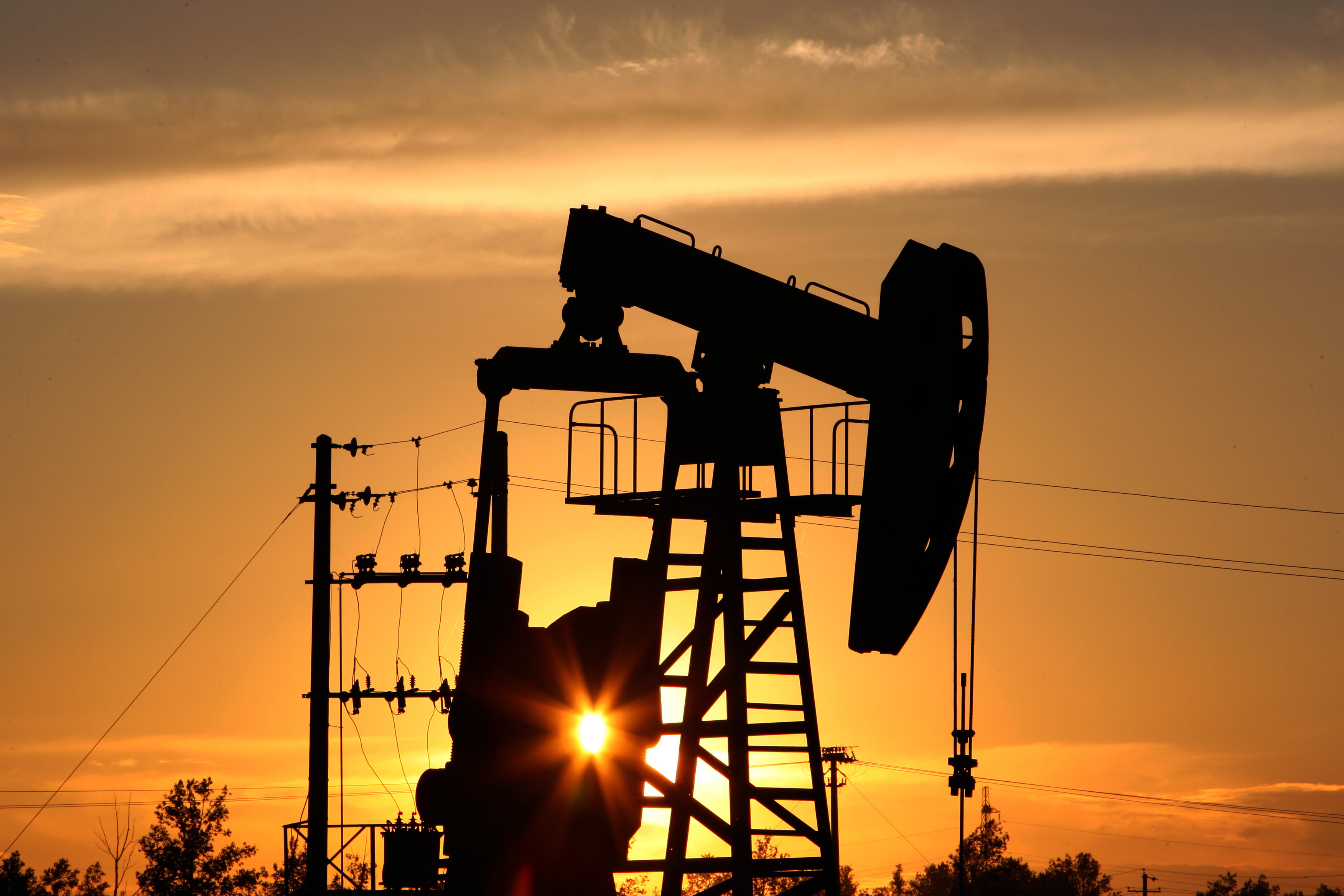 A CNPC 'nodding donkey' oil pump is seen at sunset in an oilfield outside Daqing, Heilongjiang province, China. (Lucas Schifres—Pictobank/Getty Images)