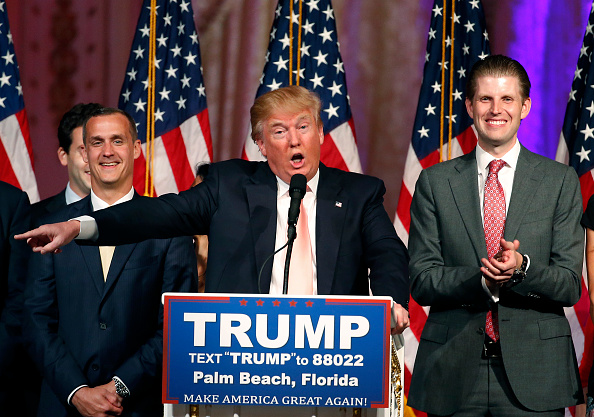 Republican presidential candidate Donald Trump (C) with his son, Eric (R), addresses the media following victory in the Florida state primary on March 15, 2016 in West Palm Beach, Florida.