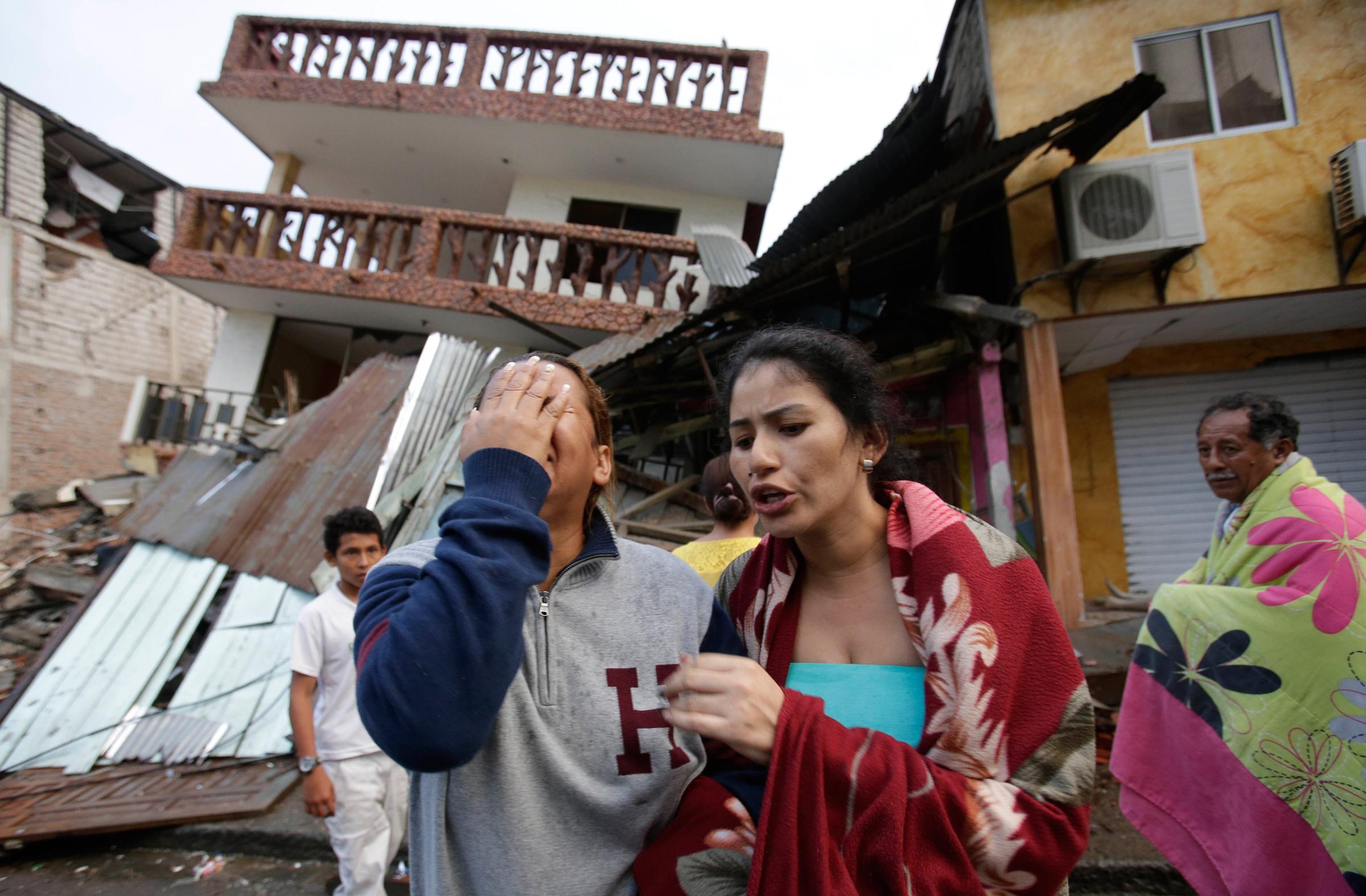 A woman cries as she stands next to house destroyed by the earthquake in the Pacific coastal town of Pedernales, Ecuador, Sunday, April 17, 2016. The strongest earthquake to hit Ecuador in decades flattened buildings and buckled highways along its Pacific coast, sending the Andean nation into a state of emergency. As rescue workers rushed in, officials said Sunday at least 77 people were killed, over 570 injured and the damage stretched for hundreds of miles to the capital and other major cities.(AP Photo/Dolores Ochoa)