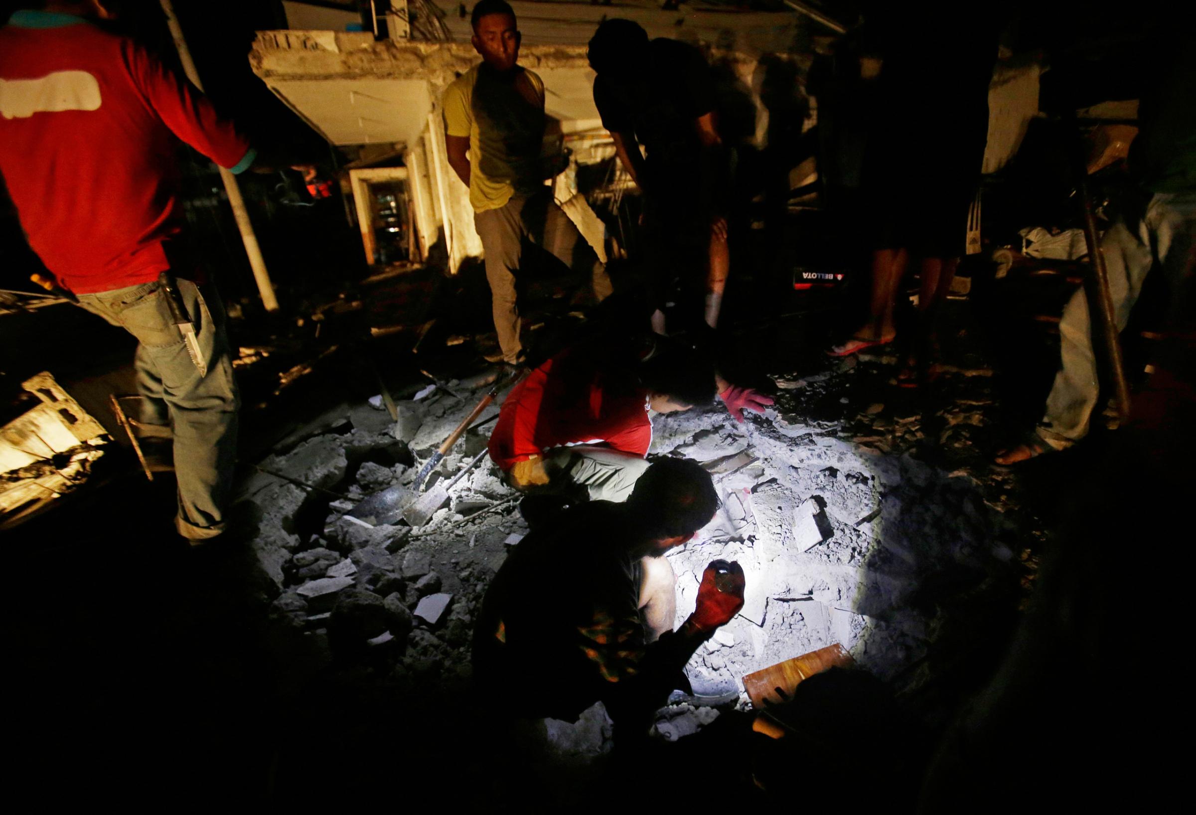 Ecuador EarthquakeResidents look for survivors in the rubble of a destroyed house sleep in the Pacific coastal town of Pedernales, Ecuador, Sunday, April 17, 2016. The strongest earthquake to hit Ecuador in decades flattened buildings and buckled highways along its Pacific coast, sending the Andean nation into a state of emergency. As rescue workers rushed in, officials said Sunday at least 77 people were killed, over 570 injured and the damage stretched for hundreds of miles to the capital and other major cities.(AP Photo/Dolores Ochoa)