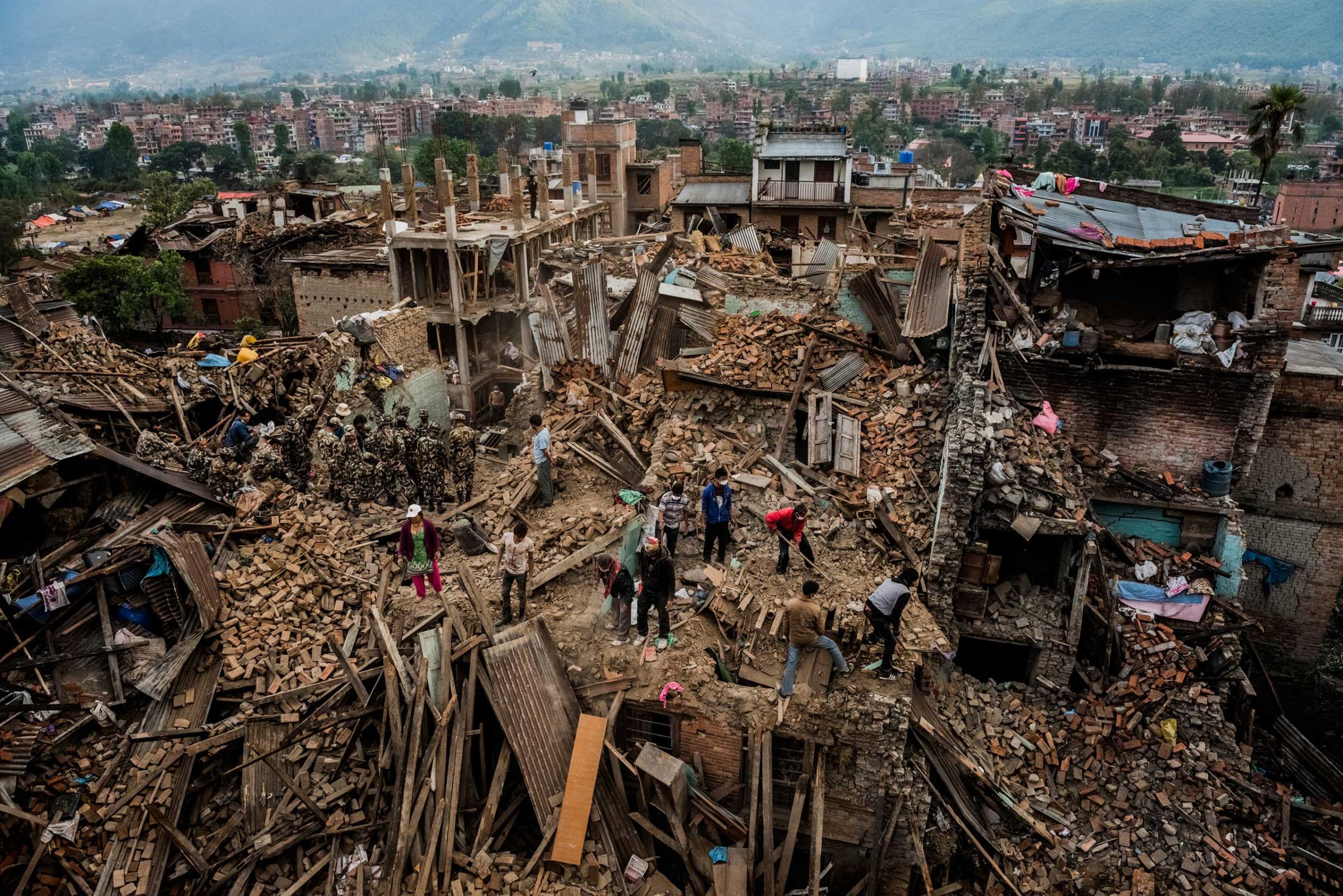 Nepalese security workers search rubble for bodies as residents try to find salvageable valuables in their earthquake-destroyed homes in Bhaktapur, Nepal. Over 2.8 million people were left homeless by the quake. April 29, 2015.