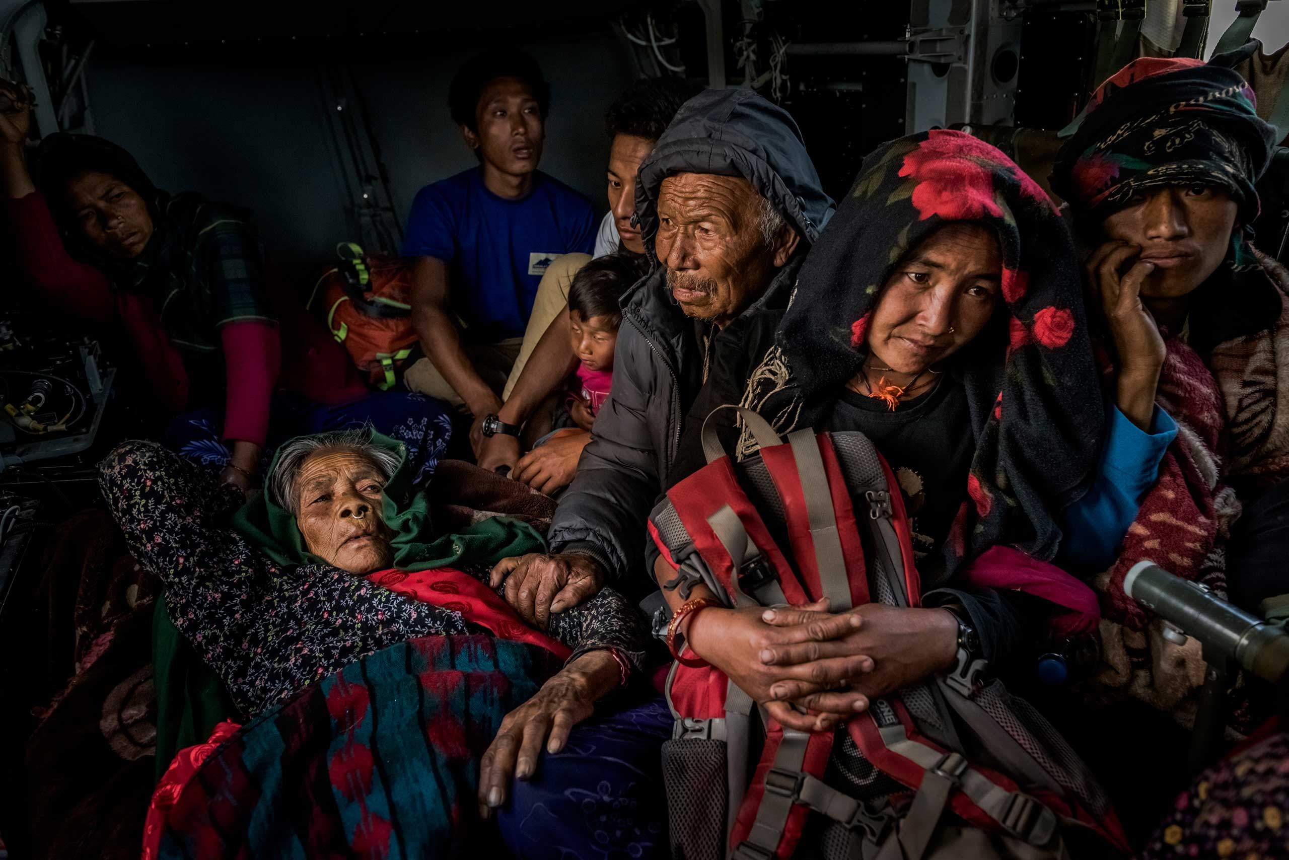 An elderly villager, left, injured during the earthquake, and fellow villagers inside an Indian Army helicopter after being evacuated from Philim, Nepal, during a joint relief and rescue mission by Indian and Nepalese military. May 3, 2015.