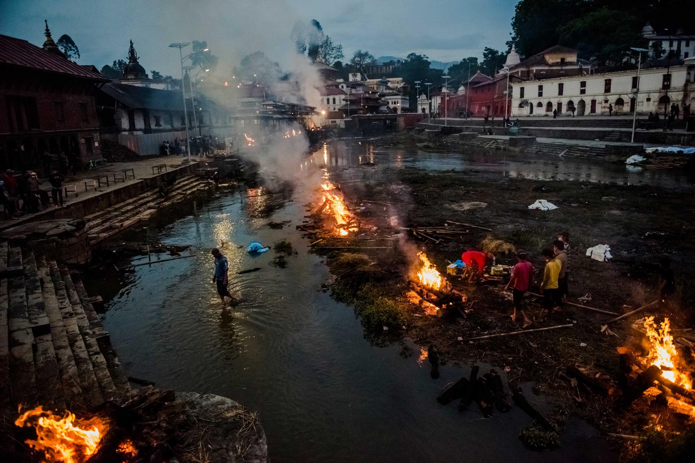 Flames rise from funeral pyres during the cremation of earthquake victims at the Pashupatinath Temple on the banks of Bagmati River, a sacred Hindu cremation site in Kathmandu, Nepal. April 28, 2015.