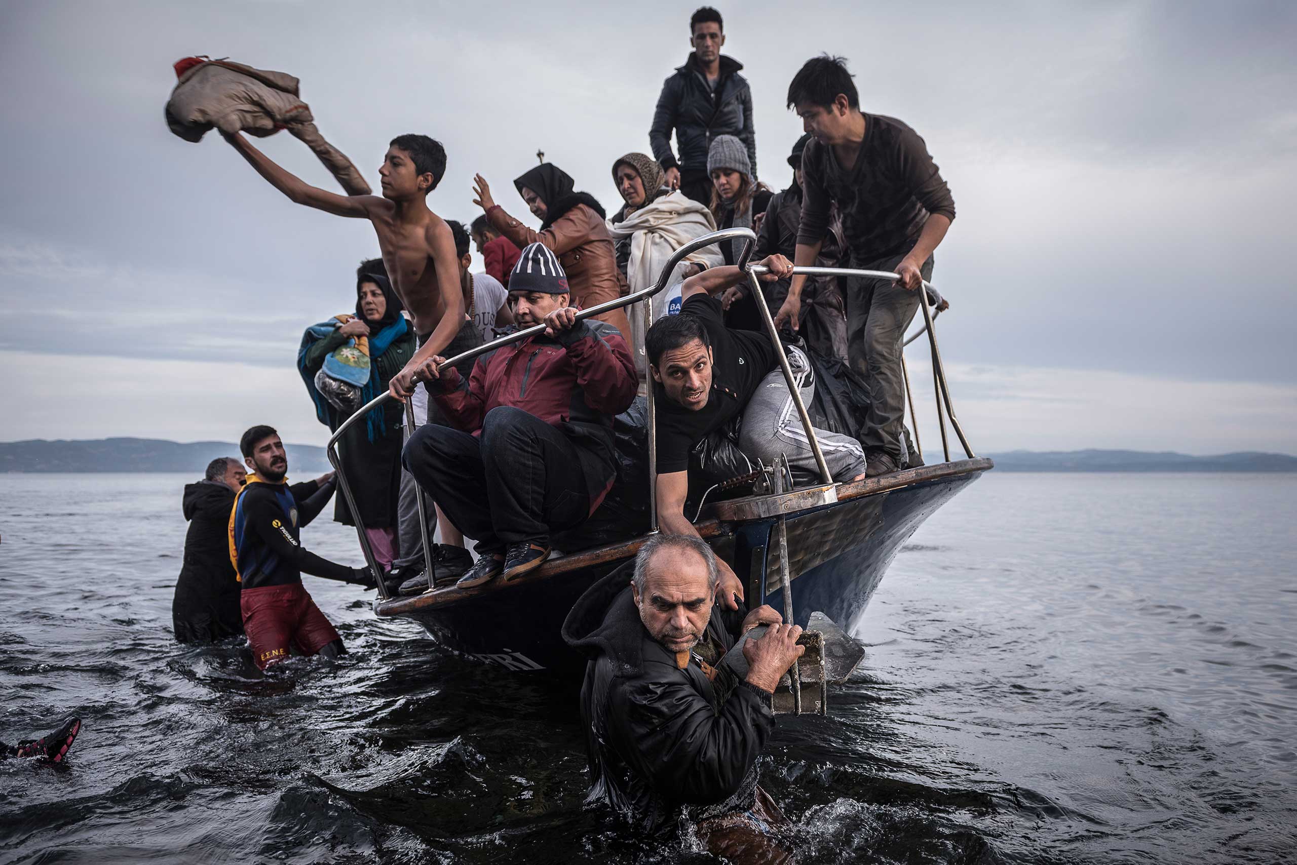 Migrants arrive by a Turkish boat near the village of Skala, on the Greek island of Lesbos. The Turkish boat owner delivered some 150 people to the Greek coast and tried to escape back to Turkey; he was arrested in Turkish waters. Nov. 16, 2015.