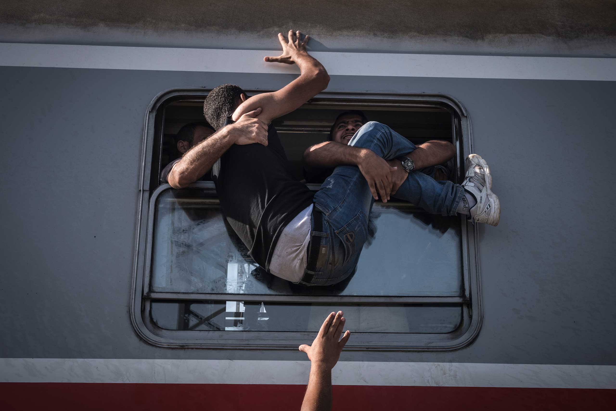 Desperate refugees board the train toward Zagreb at Tovarnik station on the border with Serbia. Sept. 18, 2015.