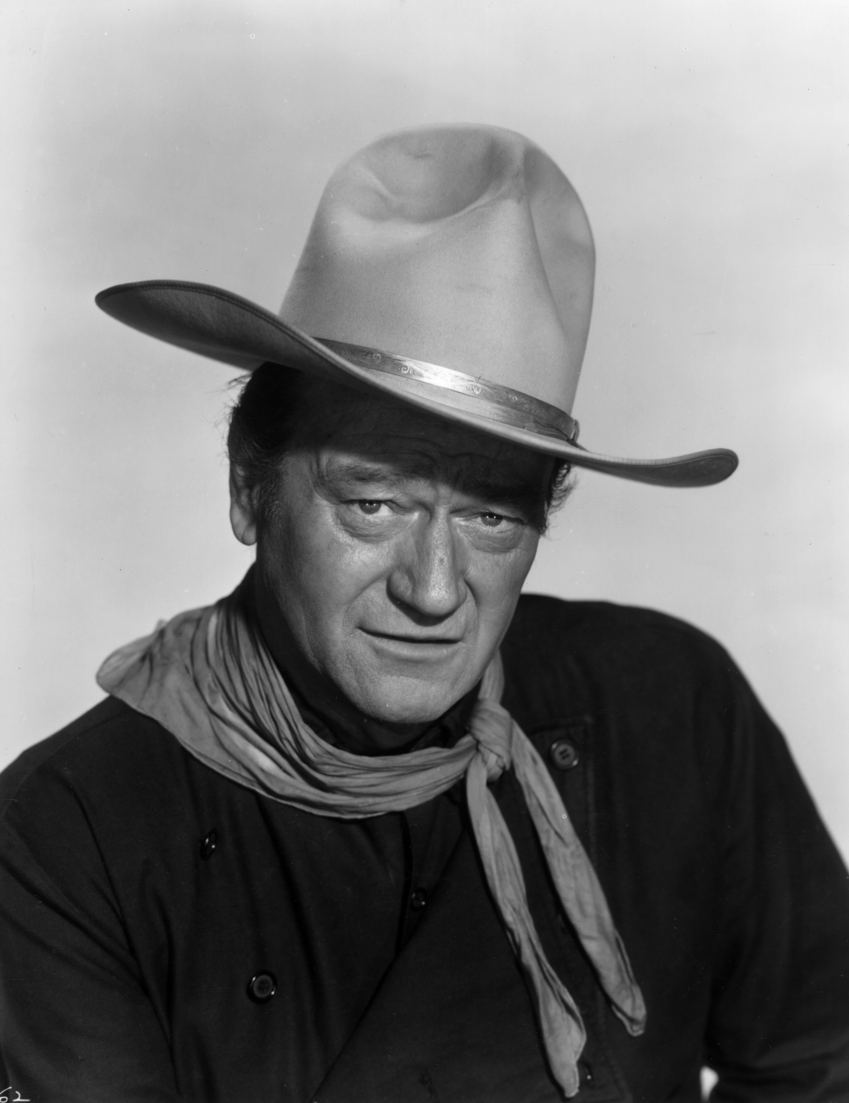 circa 1960:  Headshot portrait of American actor John Wayne (1907 - 1979) dressed as a cowboy with a bandana around his neck and a white cowboy hat on his head.  (Hulton Archive/Getty Images) (Hulton Archive&mdash;Getty Images)