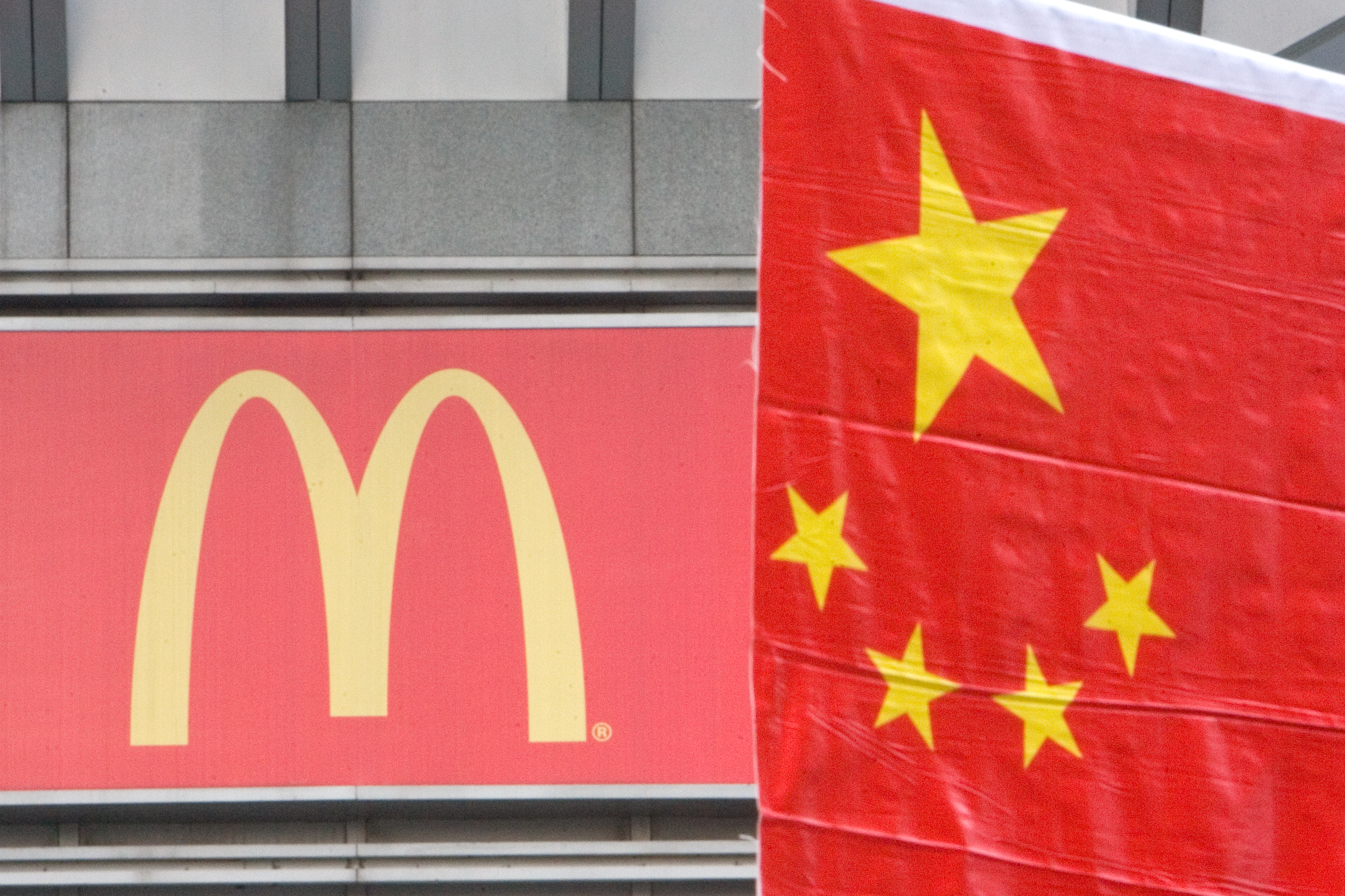 A Chinese flag is put up on Sept. 30, 2007, in Shanghai by a McDonald's sign for a celebration of China's National Day on Oct. 1 (Lucas Schifres—Getty Images)
