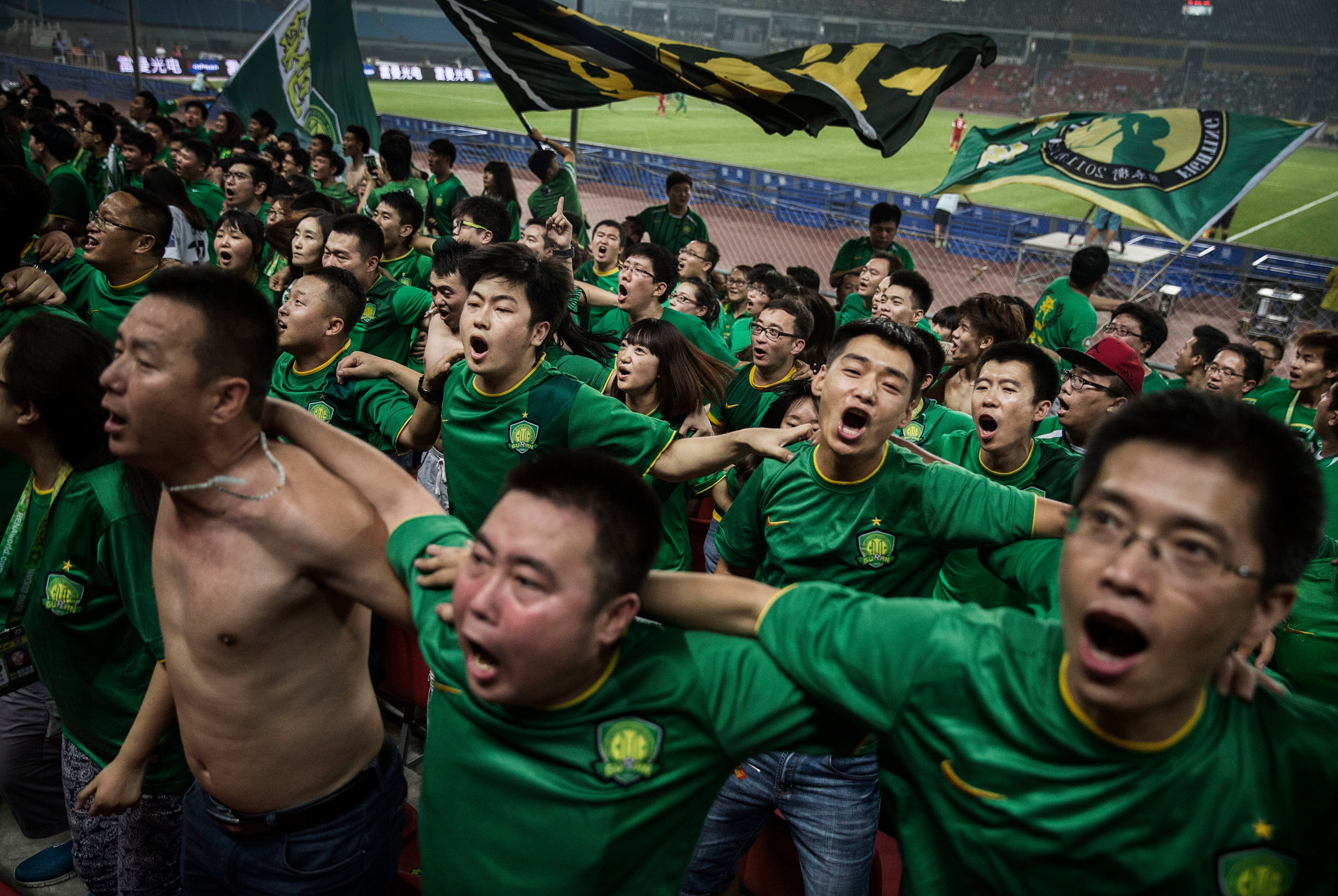 Ultra-supporters and fans of the Beijing Guoan FC celebrate together after a goal against Chongqing Lifan FC during their Chinese Super League match on June 28, 2015, in Beijing (Kevin Frayer—Getty Images)