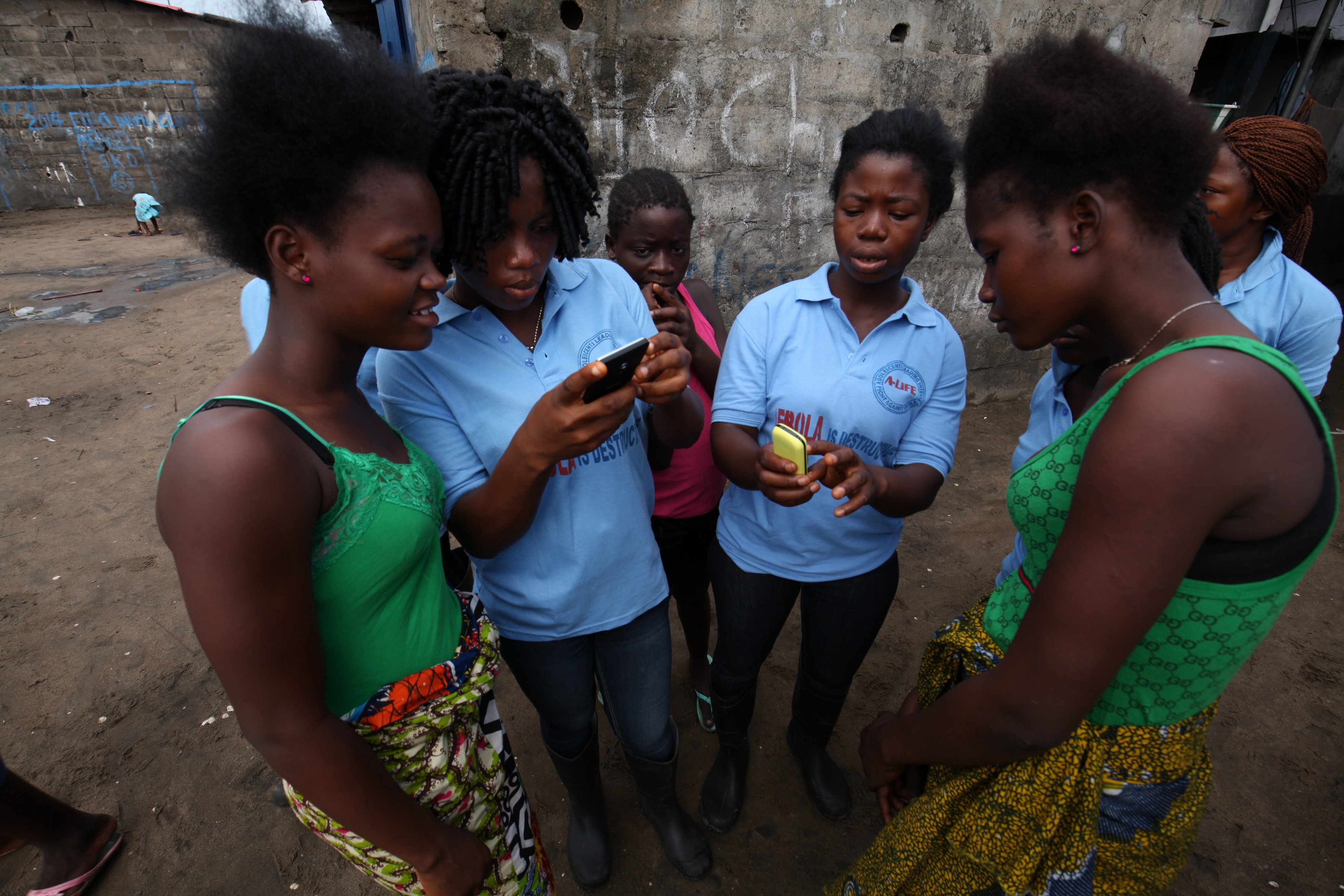 Volunteers from the A-Life adolescents group help youth
                      in West Point, Monrovia, Liberia register on U-Report, a
                      sms-based platform that enables over 71,000 youth to receive information and share
                      issues that are relevant to them. (UNICEF/2014/Jallonzo)